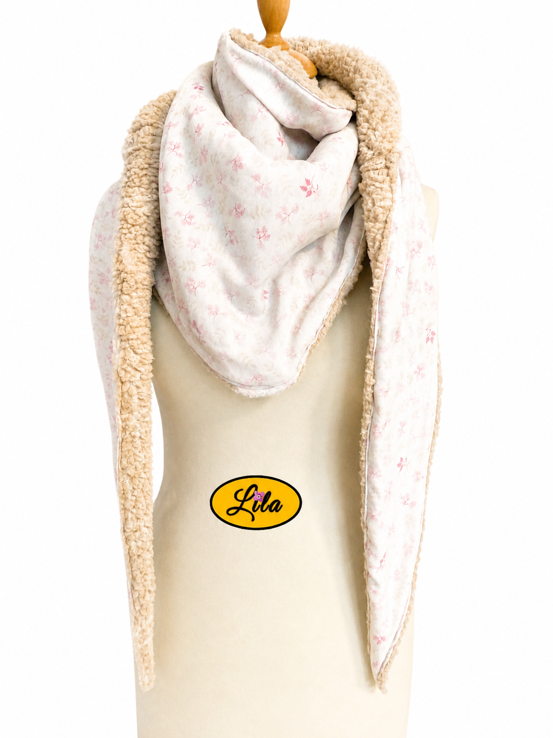 Foulard triangulaire en coton blanc à motifs roses avec doublure polaire teddy brune porté sur mannequin de couture sur fond blanc style romantique et hivernal