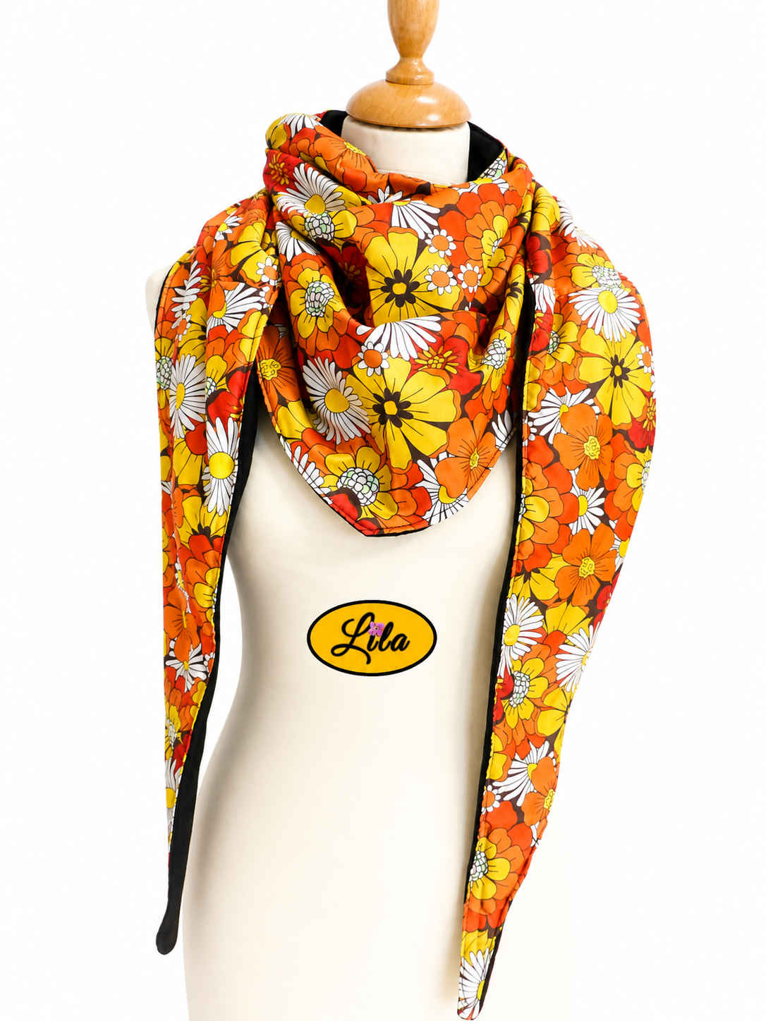 Foulard triangulaire en tissu fleuri orange vintage avec doublure polaire noire porté sur mannequin de couture sur fond blanc style rétro et hivernal