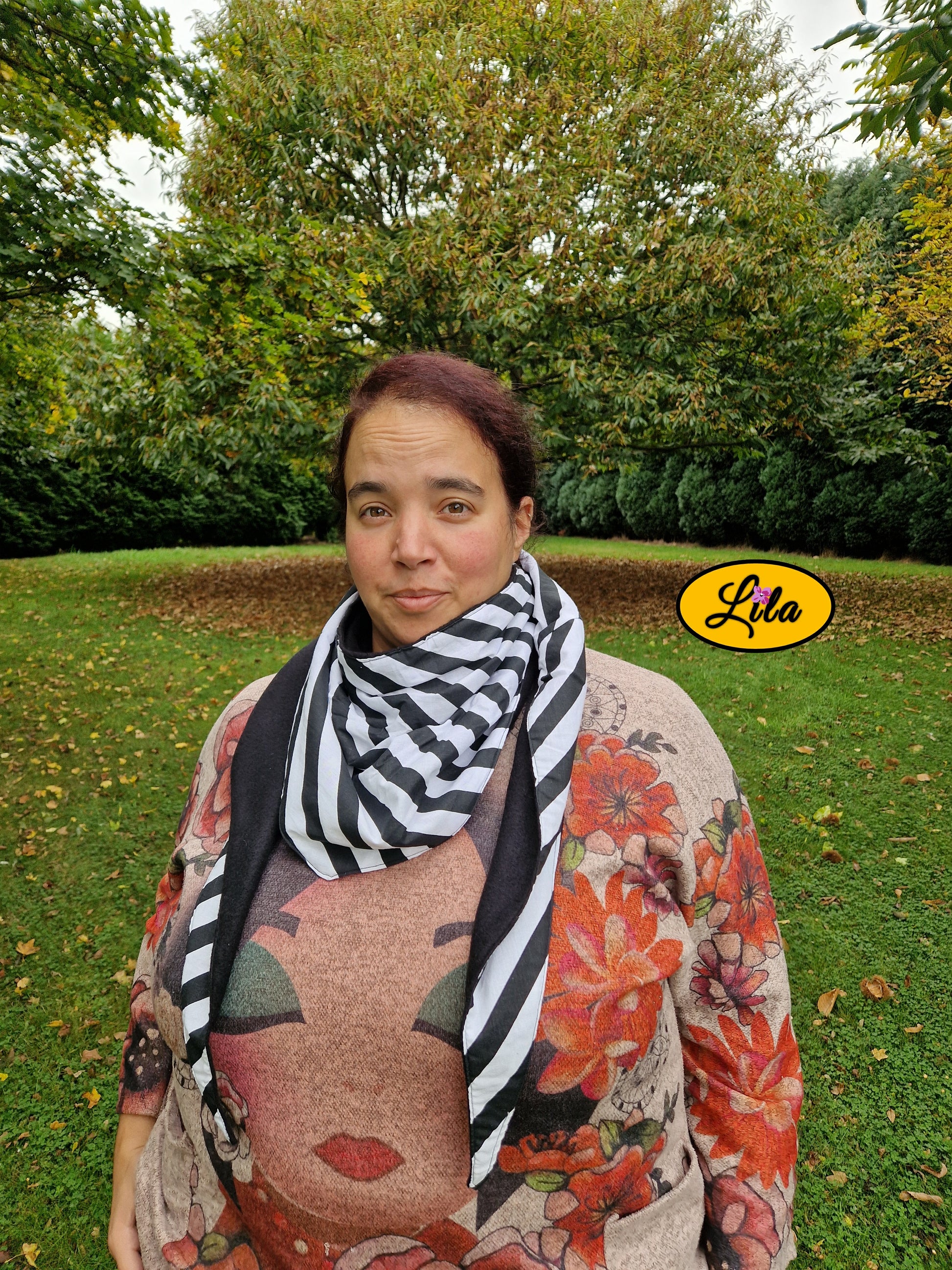 Foulard triangulaire à lignes noir et blanc porté par une jeune femme dans un parc automnal photo cadrée à la taille style moderne et cocooning