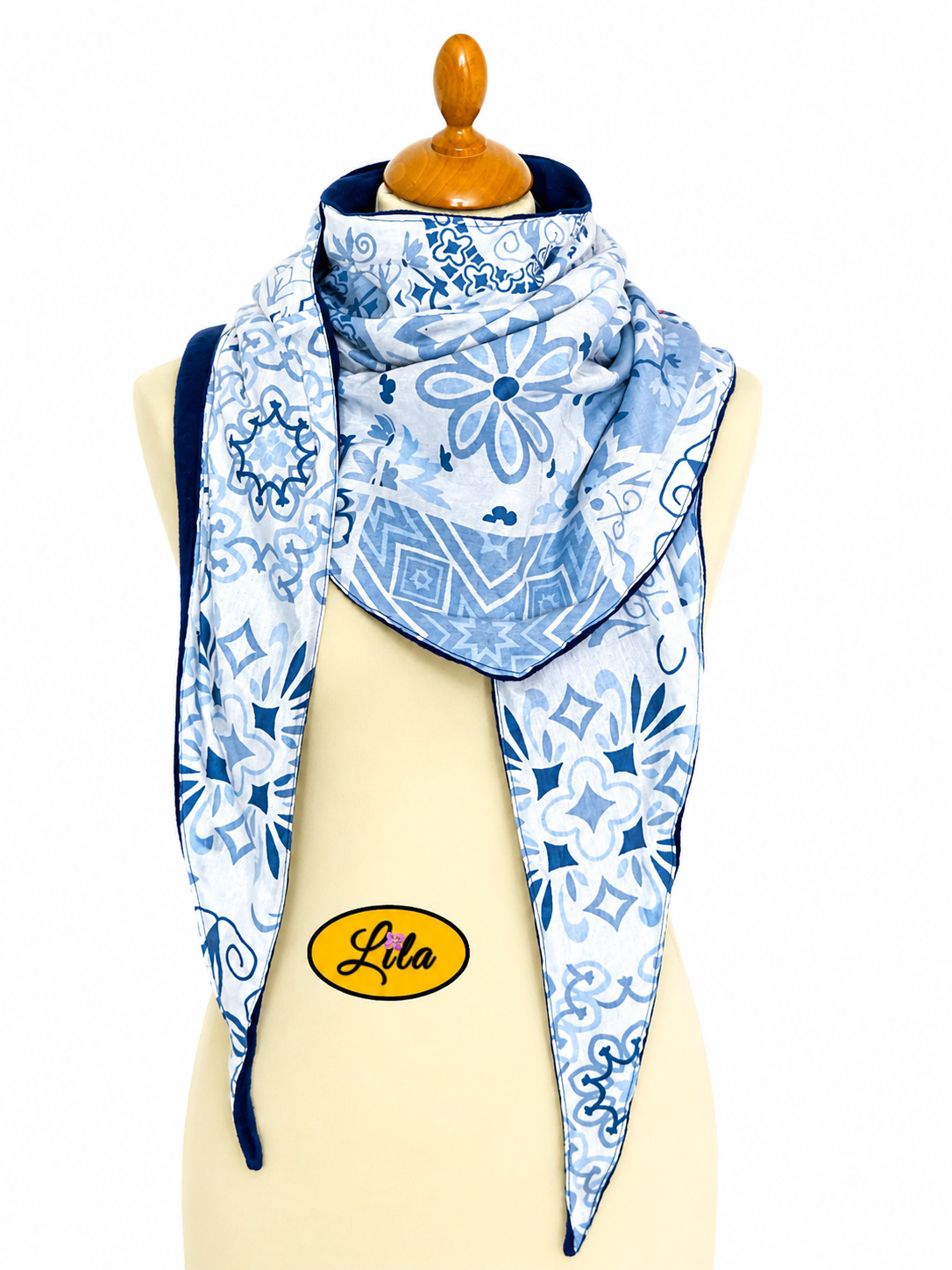 Foulard triangulaire à motifs bleus avec doublure polaire bleu marine porté sur mannequin de couture sur fond blanc style hivernal et élégant