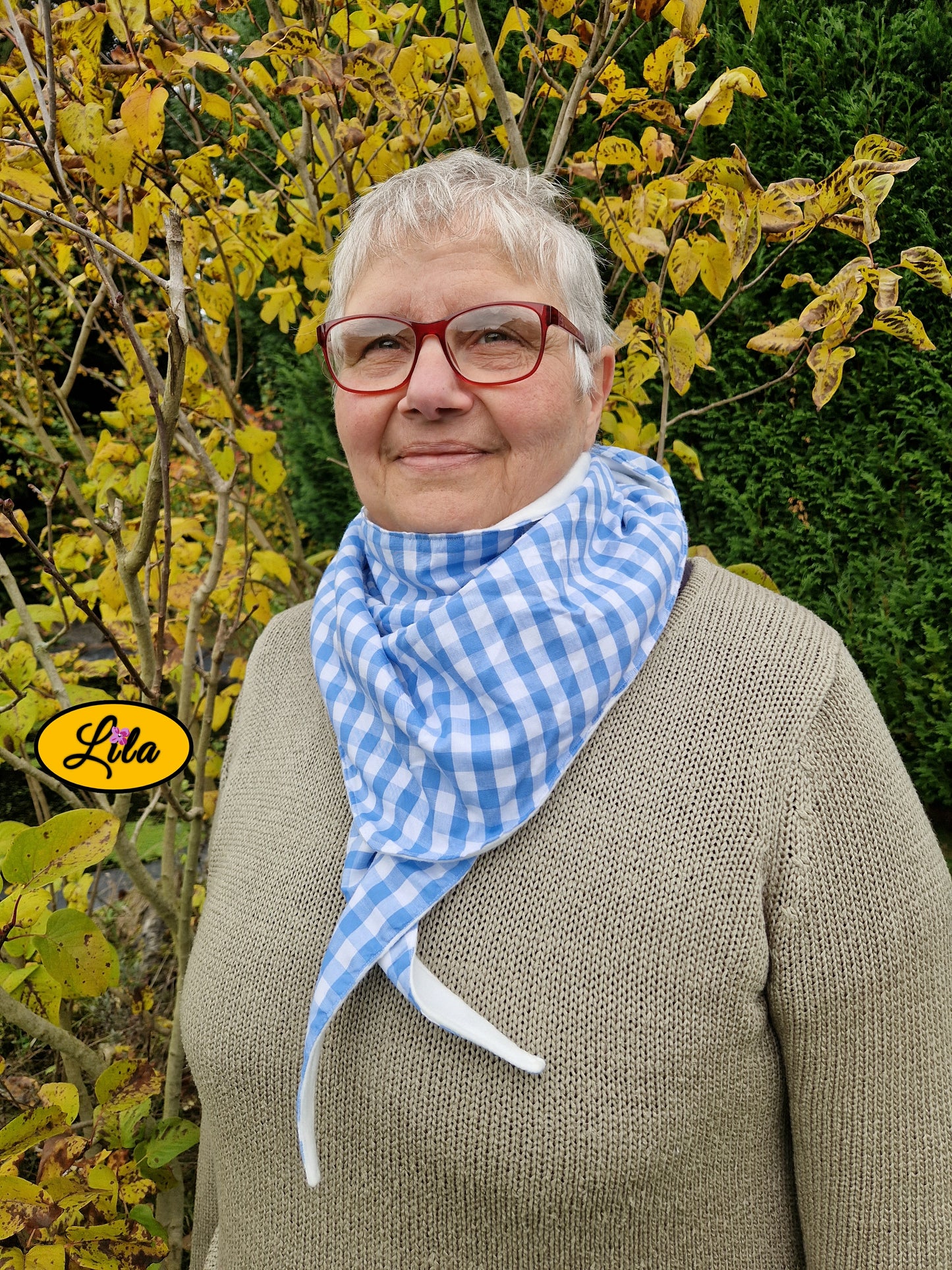 Foulard triangulaire rétro en tissu vichy bleu et blanc porté noué par une dame avec nœud dissimulé sous la pointe du foulard style élégant et vintage