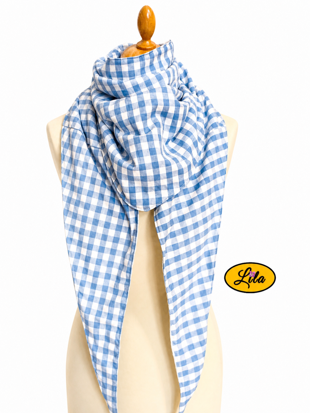 Foulard triangulaire rétro en tissu vichy bleu et blanc avec doublure polaire blanche porté sur mannequin de couture sur fond blanc style vintage et hivernal