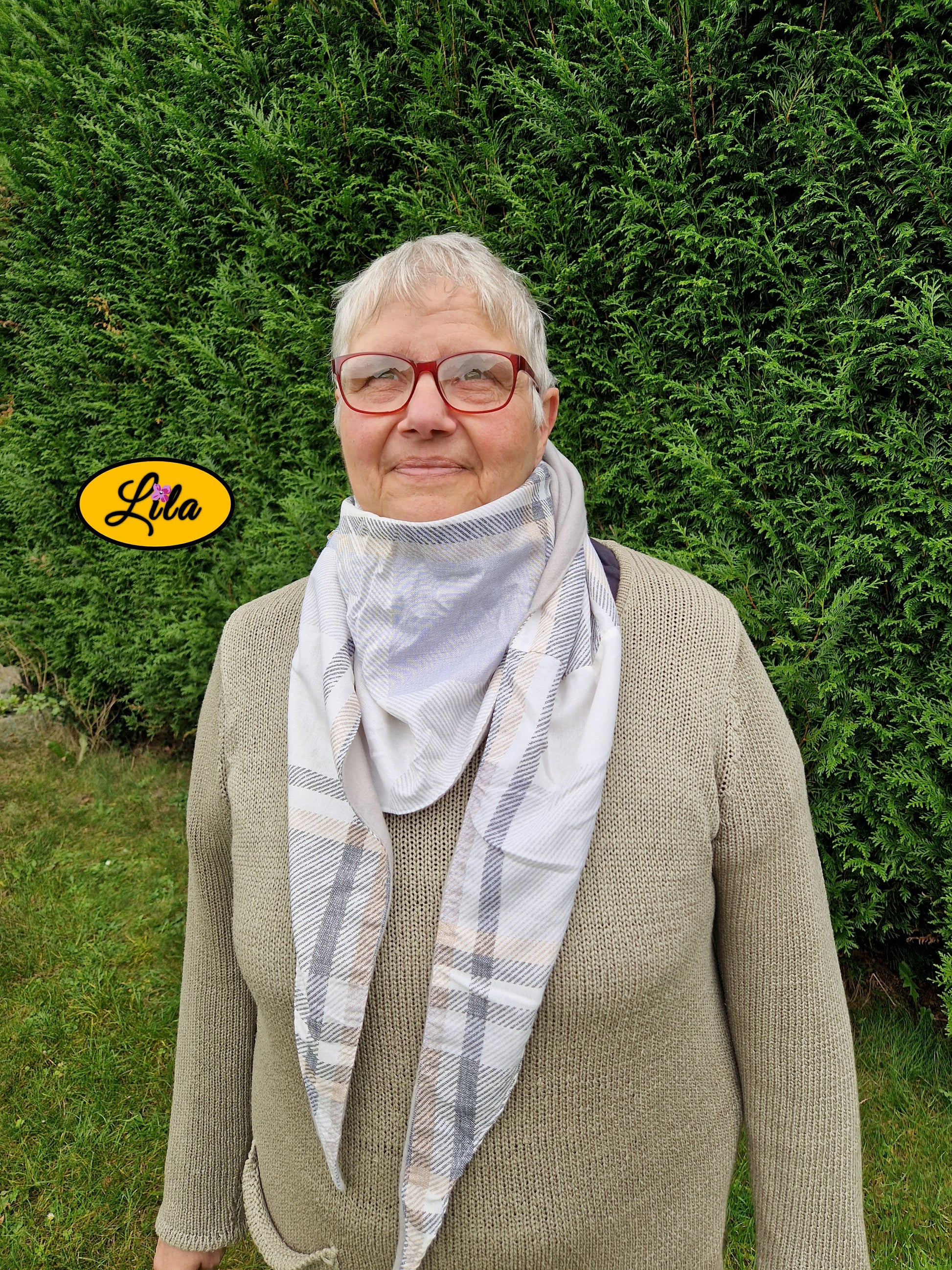 Foulard triangulaire vintage à lignes brun et gris porté par une dame à lunettes dans un jardin automnal vue plus de face style chaleureux et élégant