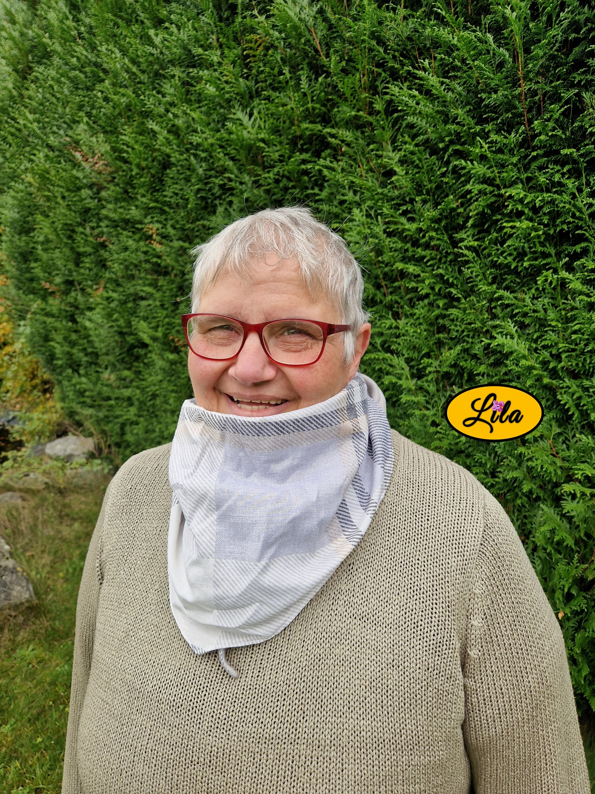 Gros plan sur le foulard triangulaire vintage à lignes brun et gris porté fermé avec nœud caché sous la pointe style rétro et cocooning