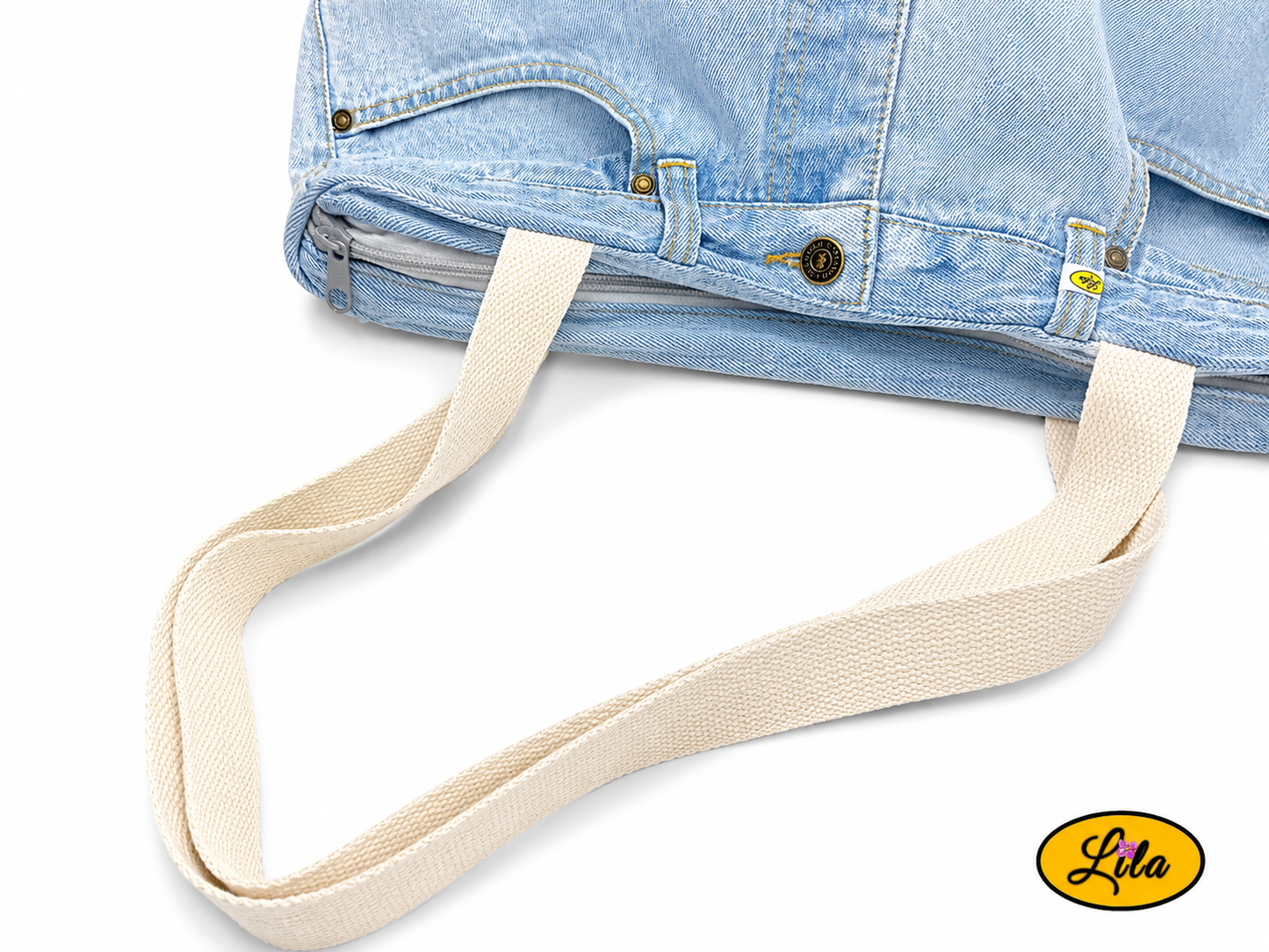 Zoom sur la sangle d'un grand sac en jeans clair recyclé et simili cuir crème mettant en valeur les matériaux et les finitions artisanales