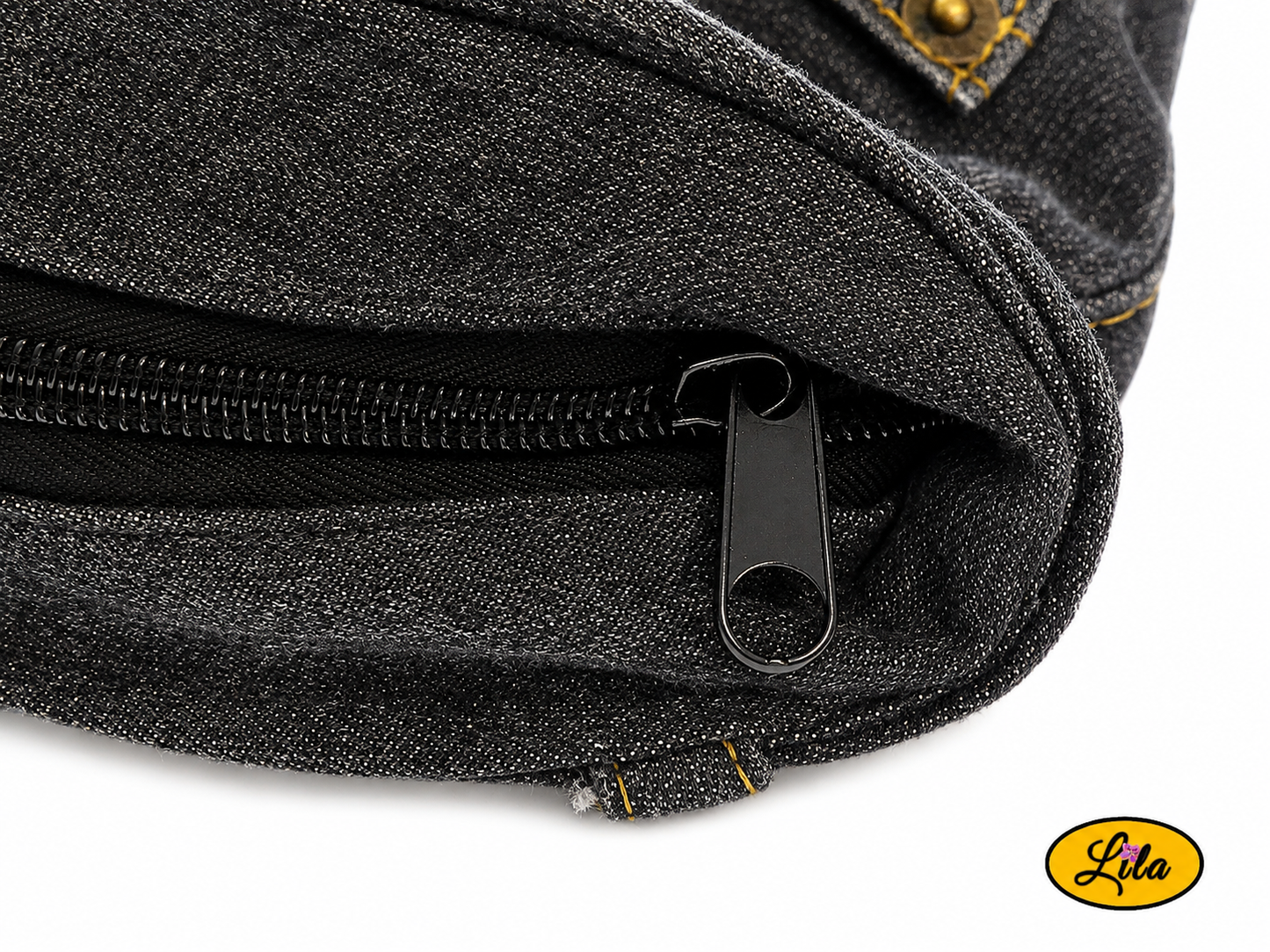 Zoom sur la fermeture éclair d'un grand sac en jeans noir recyclé et simili cuir gris foncé mettant en valeur les finitions soignées de la création artisanale