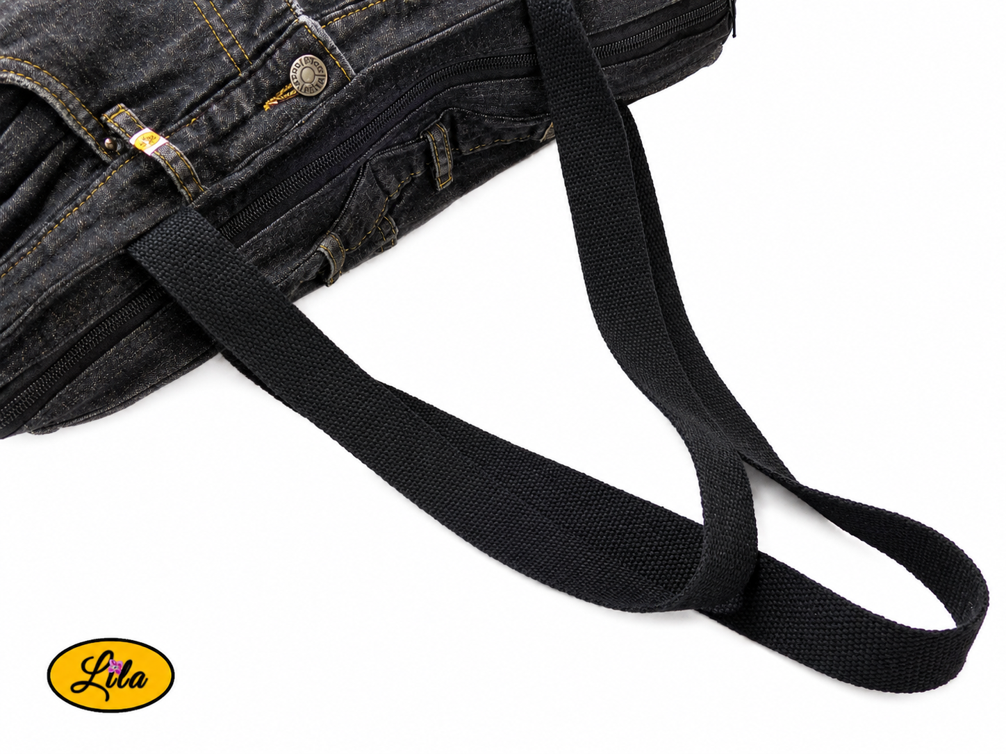 Zoom sur la sangle d'un grand sac en jeans noir recyclé et simili cuir gris foncé mettant en valeur la qualité des matériaux et les finitions artisanales