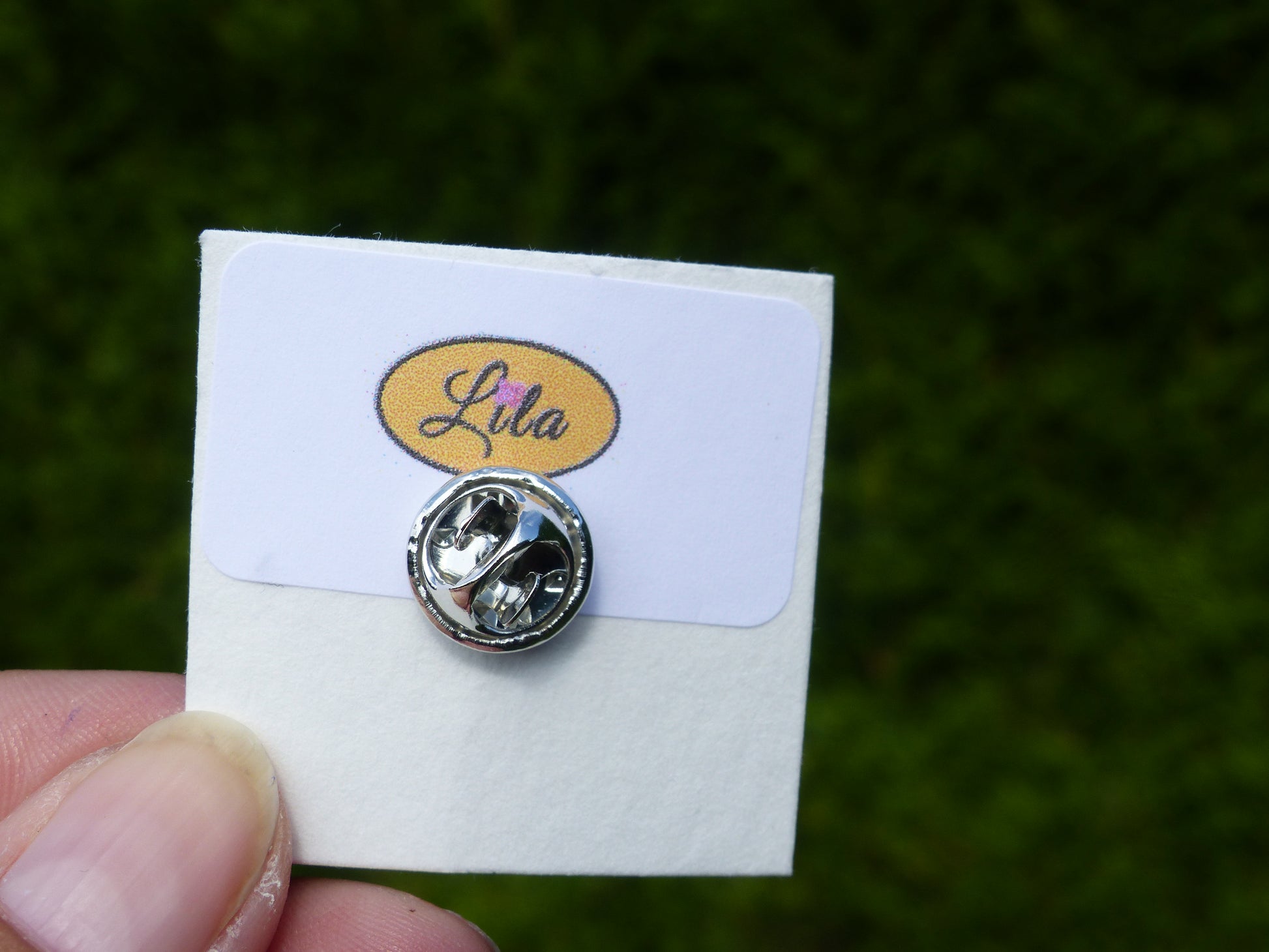Arrière d’un pin’s avec attache argentée vue détail