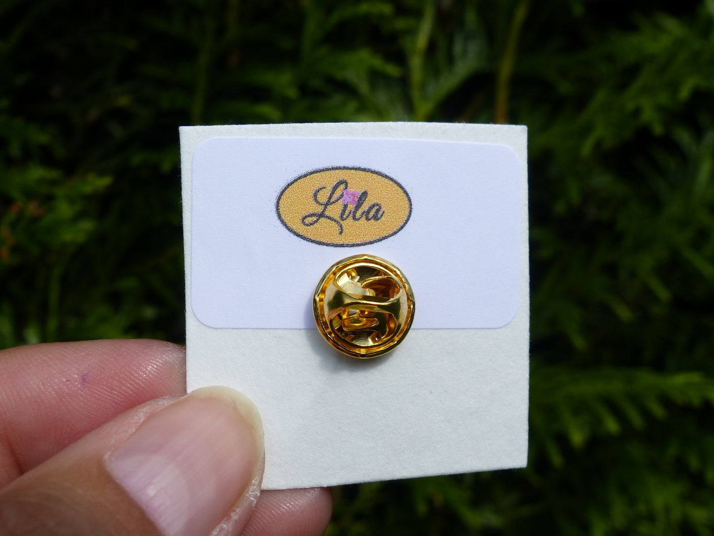 Arrière d’un pin’s avec attache dorée vue détail