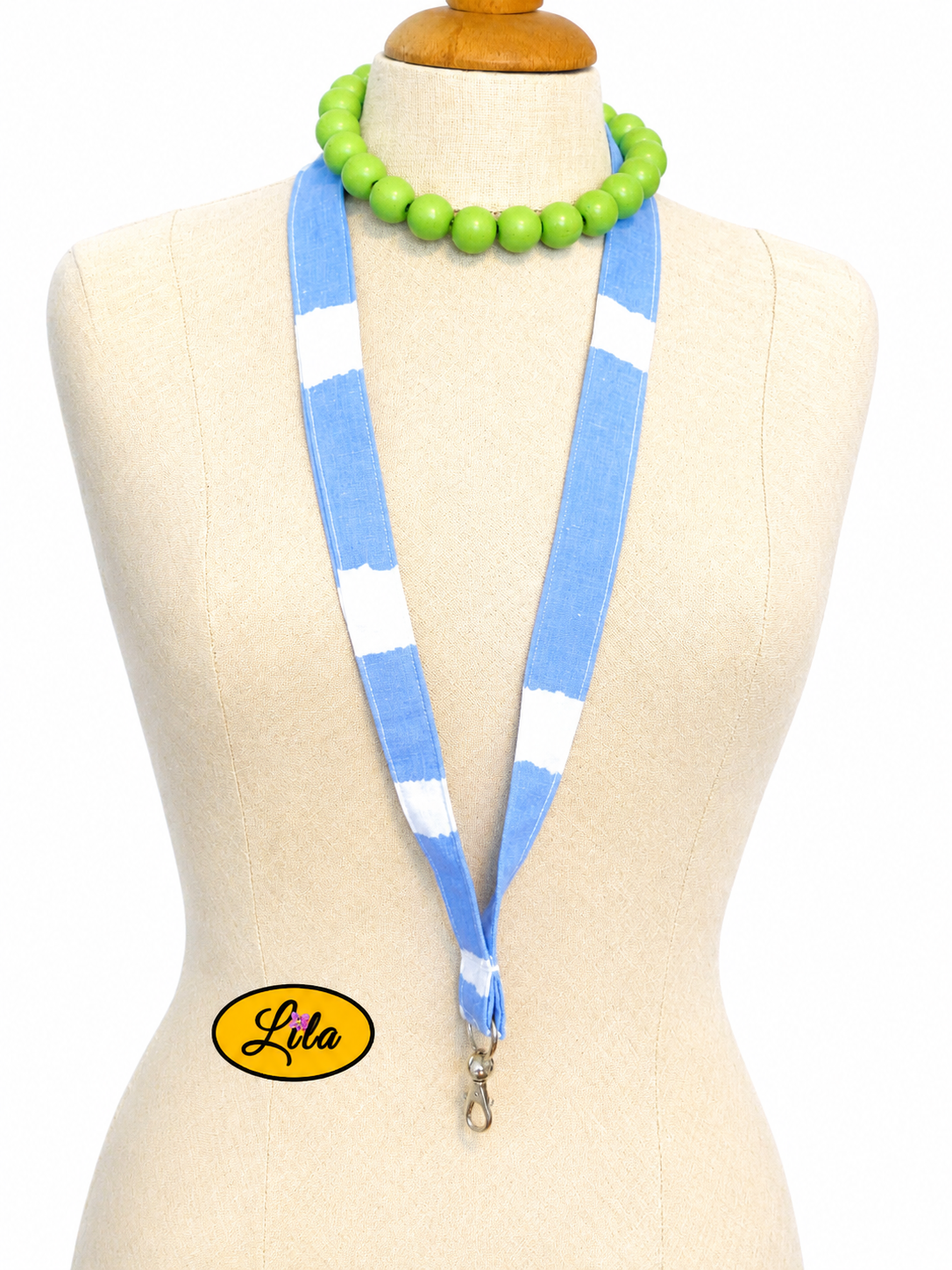 Porte-badge en tissu bleu à lignes blanches irrégulières et vagues porté sur mannequin de couture sur fond blanc avec mousqueton style moderne et artisanal