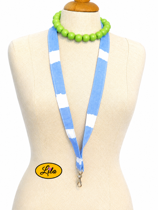Porte-badge en tissu bleu à lignes blanches irrégulières et vagues porté sur mannequin de couture sur fond blanc avec mousqueton style moderne et artisanal