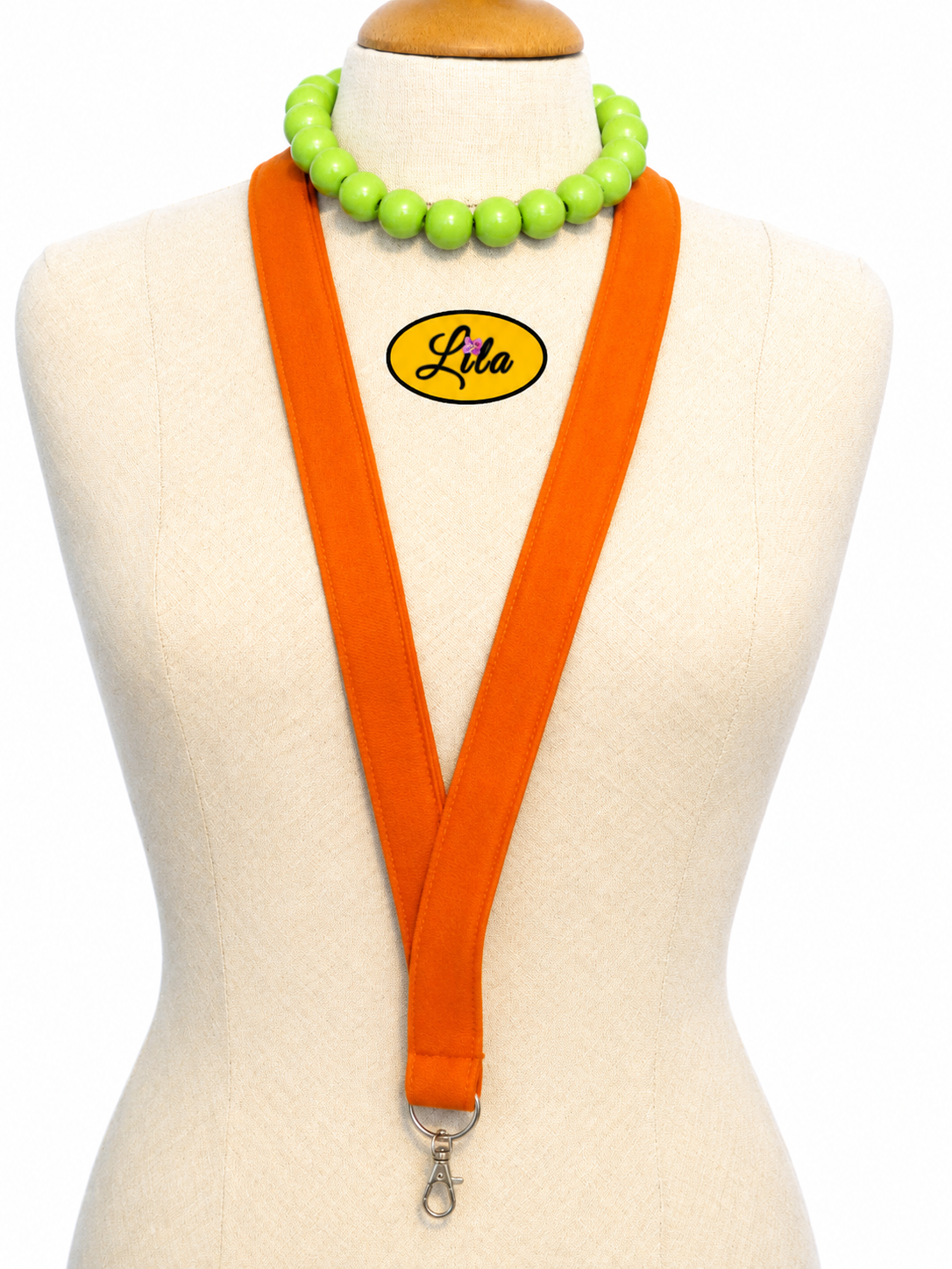 Porte-badge orange en tissu épais porté sur mannequin de couture sur fond blanc avec mousqueton style moderne et artisanal