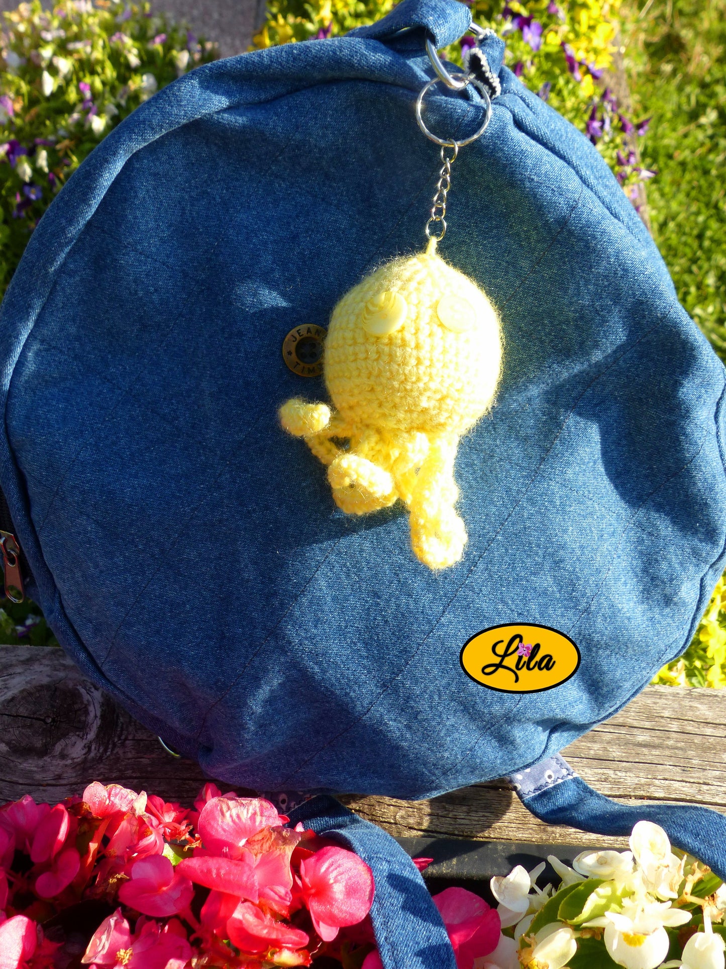 Porte-clé Poulpy pieuvre amigurumi jaune réalisée au crochet avec yeux en boutons jaunes de différentes teintes accroché à un sac style bohème et artisanal