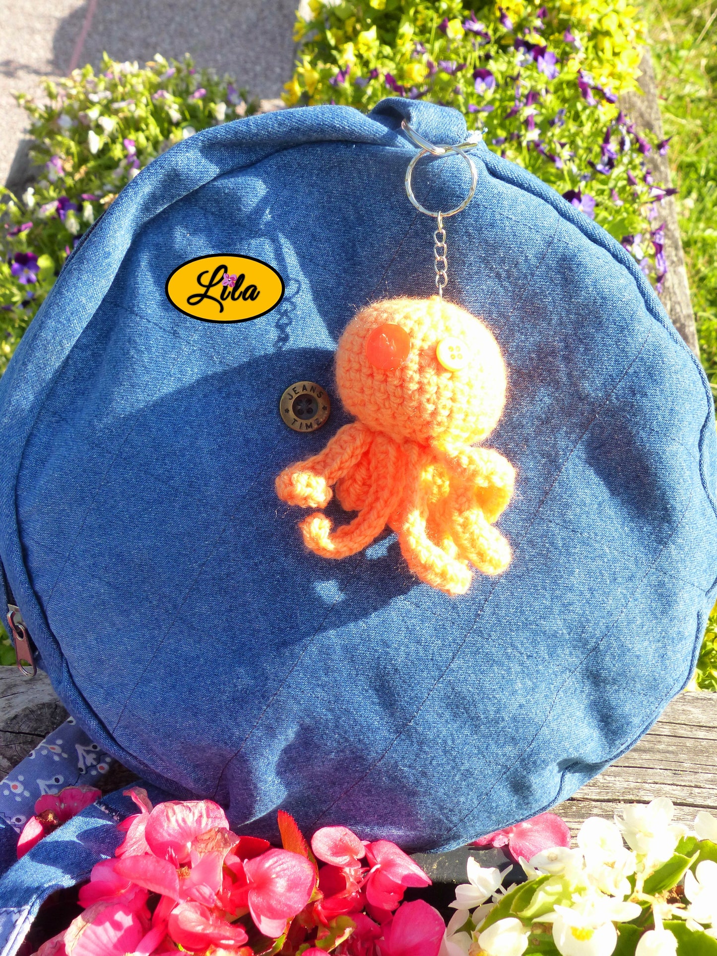 Porte-clé Poulpy pieuvre amigurumi orange réalisée au crochet avec yeux en boutons orange accroché à un sac style bohème et artisanal