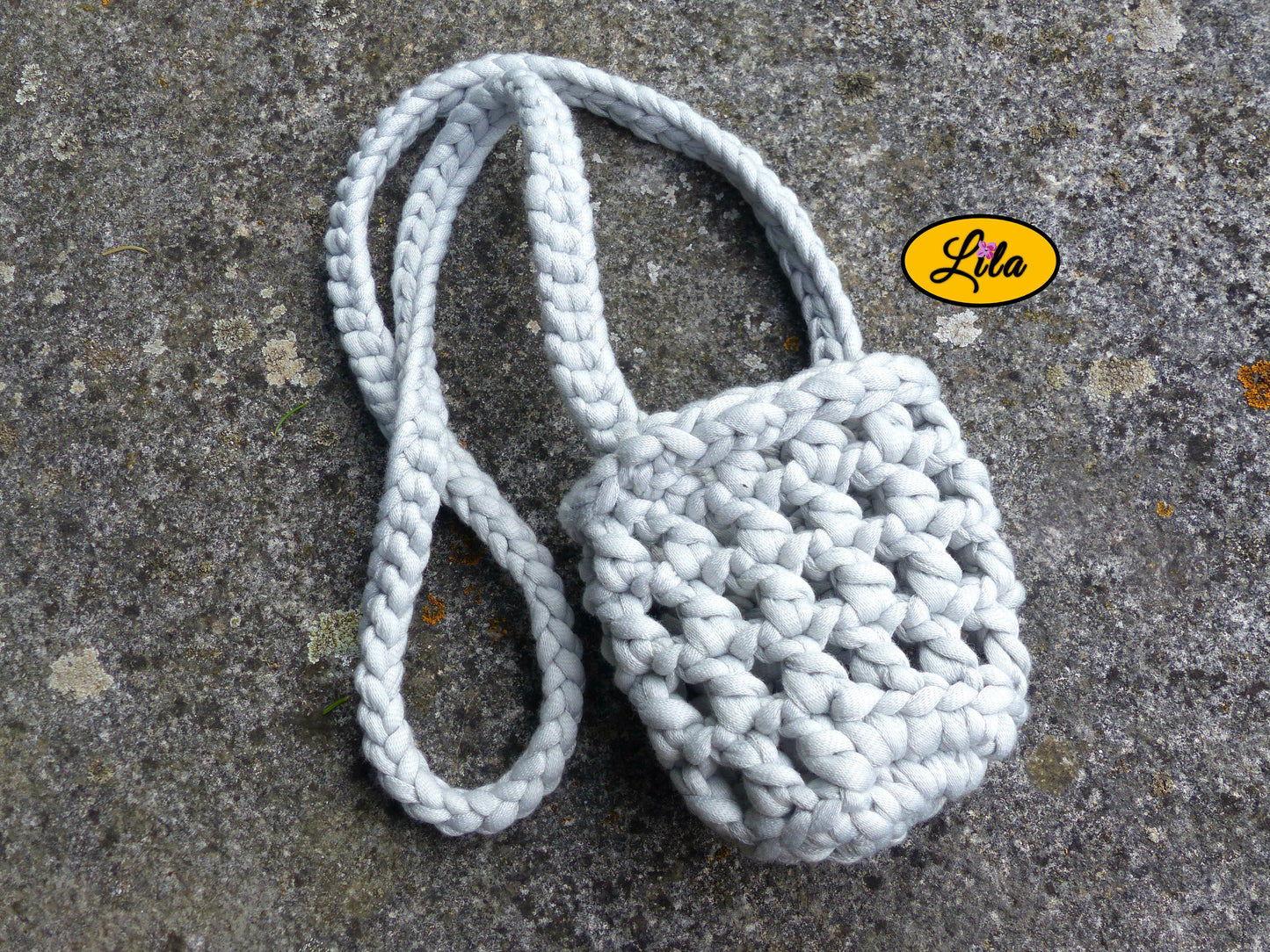 Porte-gobelet gris vu de haut à plat sur une pierre avec tresse placée sur le côté droit du porte-gobelet style minimaliste et festival