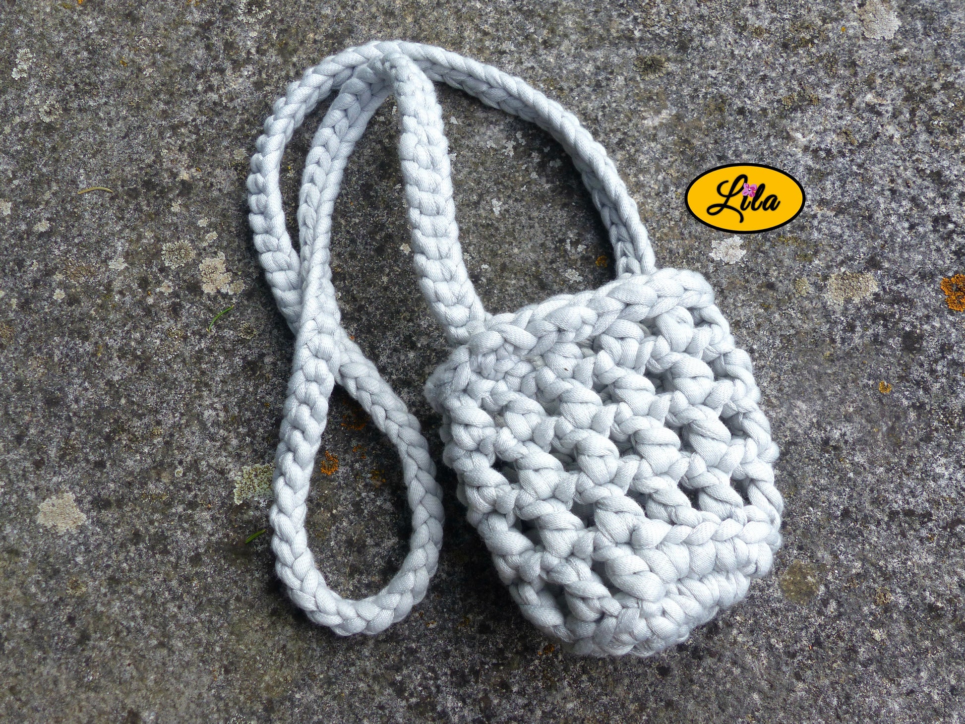 Porte-gobelet gris vu de haut à plat sur une pierre avec tresse placée sur le côté droit du porte-gobelet style minimaliste et festival