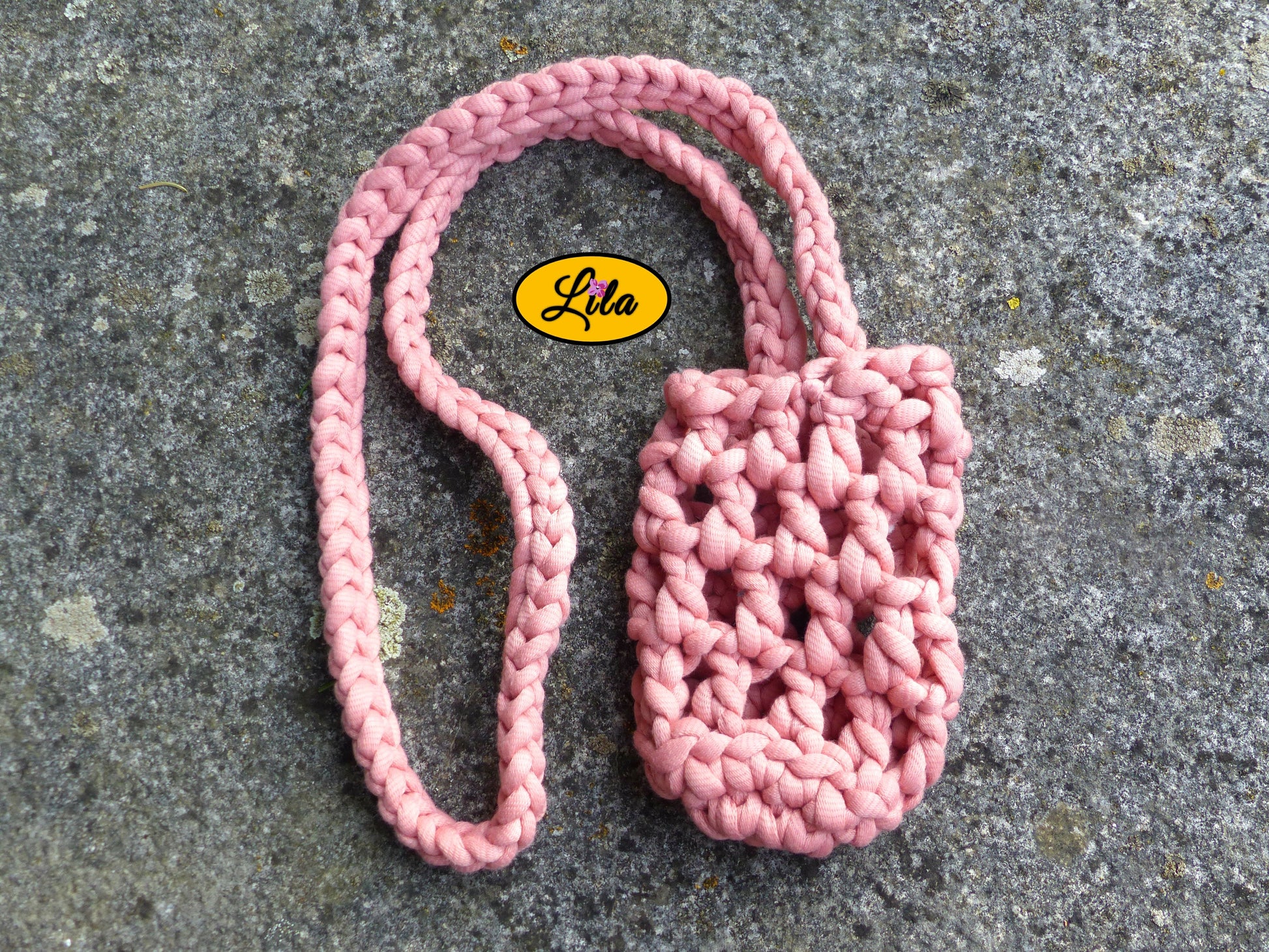 Porte-gobelet rose vu de haut à plat sur une pierre avec tresse placée sur le côté droit du porte-gobelet style bohème et festival