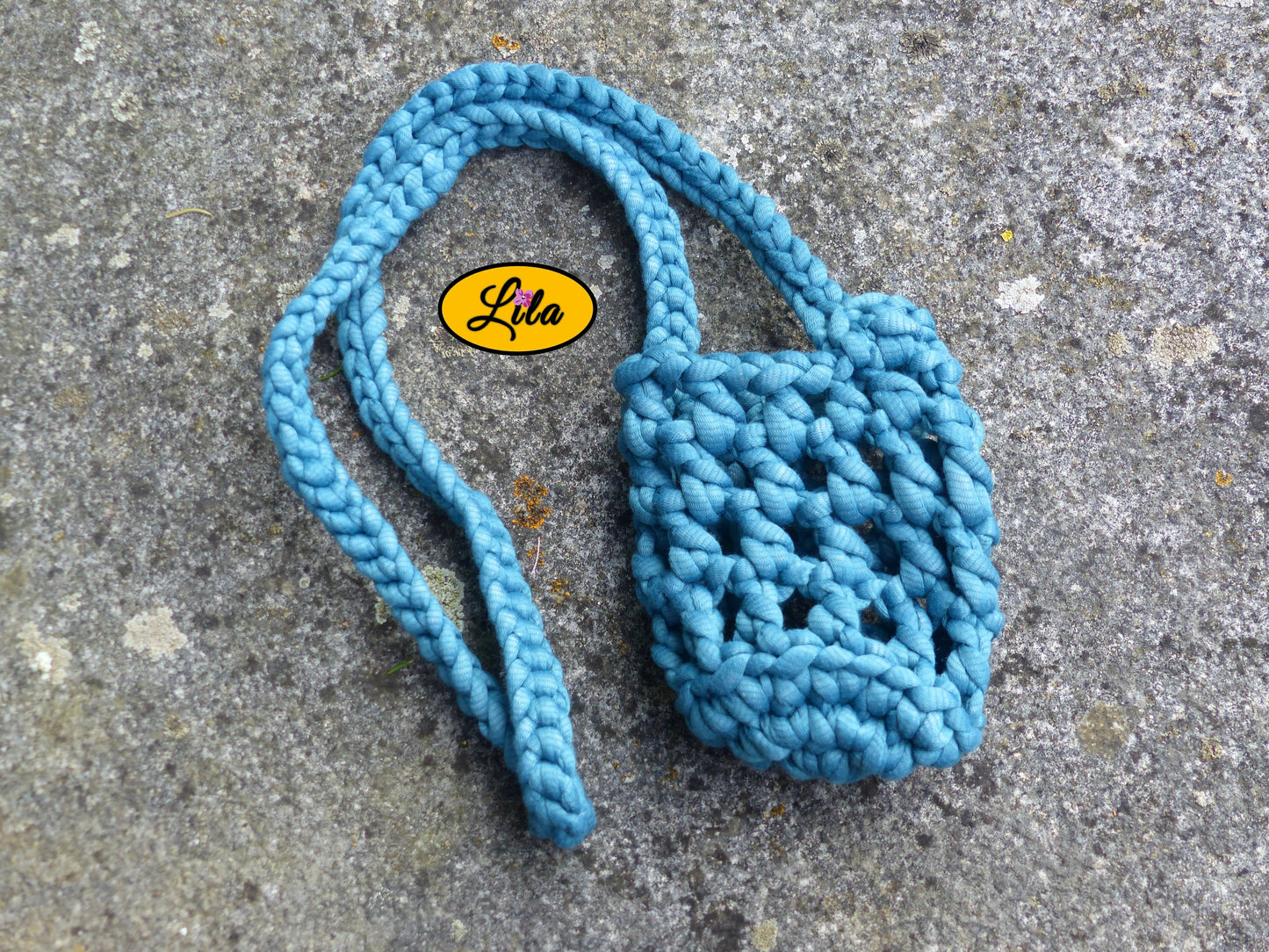 Porte-gobelet turquoise vu de haut à plat sur une pierre avec tresse placée sur le côté droit du porte-gobelet style bohème et festival