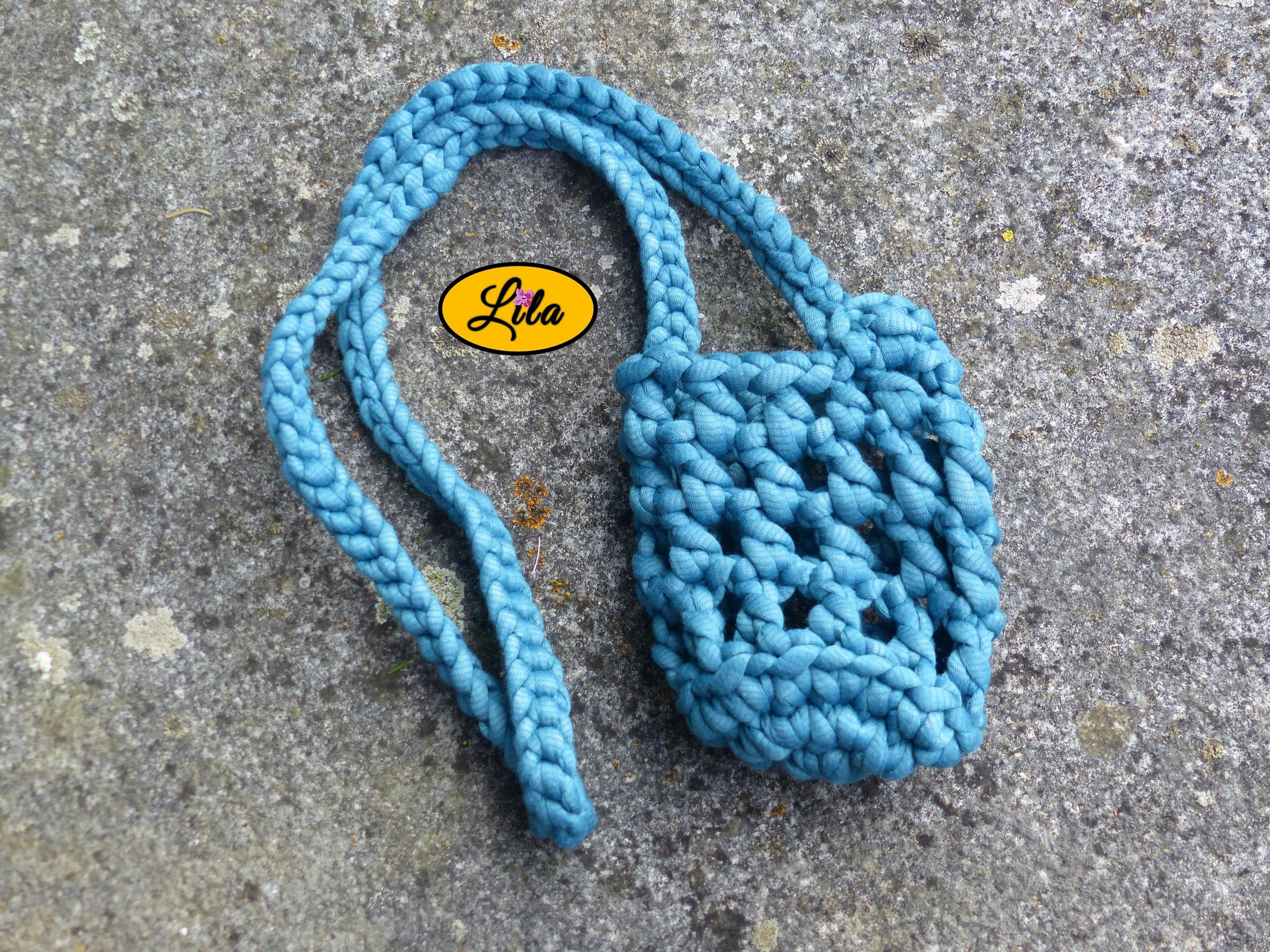 Porte-gobelet turquoise vu de haut à plat sur une pierre avec tresse placée sur le côté droit du porte-gobelet style bohème et festival