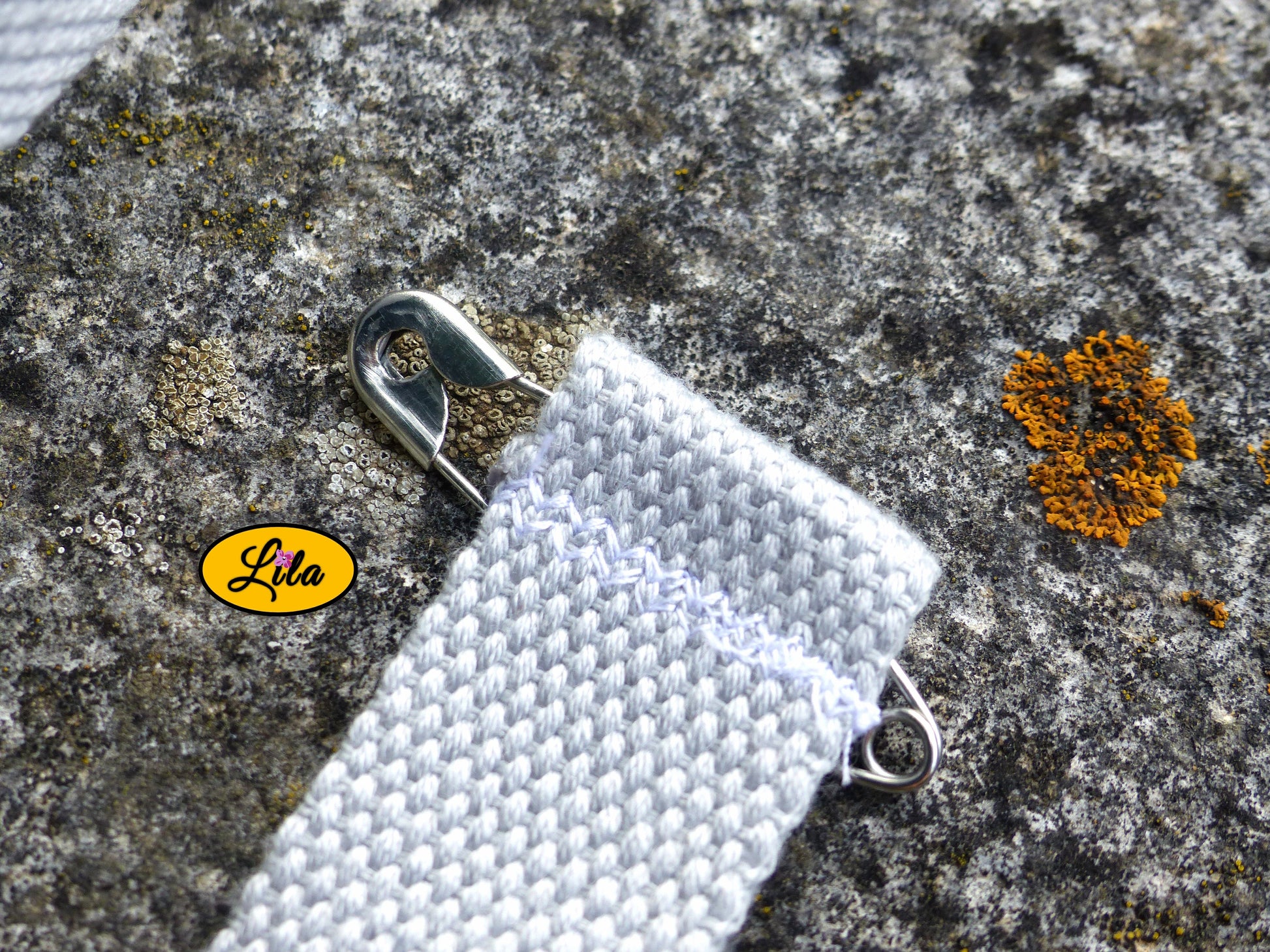 Zoom sur l’épingle de fixation d’un porte-gobelet crocheté gris avec ceinture grise style festival et fonctionnel
