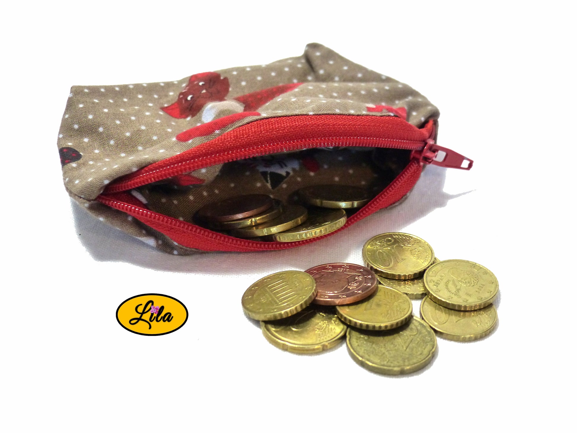 Porte-monnaie en tissu brun à motifs chats ouvert avec pièces de monnaie qui en sortent sur fond blanc et fermeture éclair rouge style artisanal et fonctionnel
