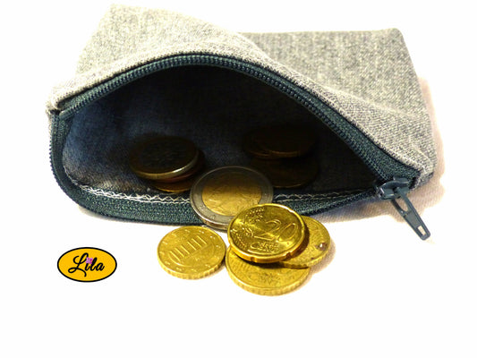 Porte-monnaie en ancien jeans noir recyclé ouvert avec pièces de monnaie qui en sortent sur fond blanc style upcyclé et fonctionnel