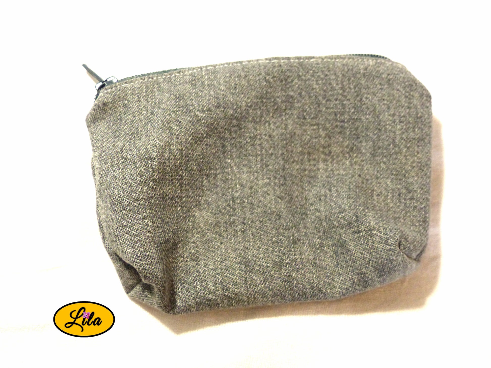Porte-monnaie en ancien jeans noir recyclé avec fermeture éclair grise posé de face vue de haut sur fond blanc style urbain et artisanal