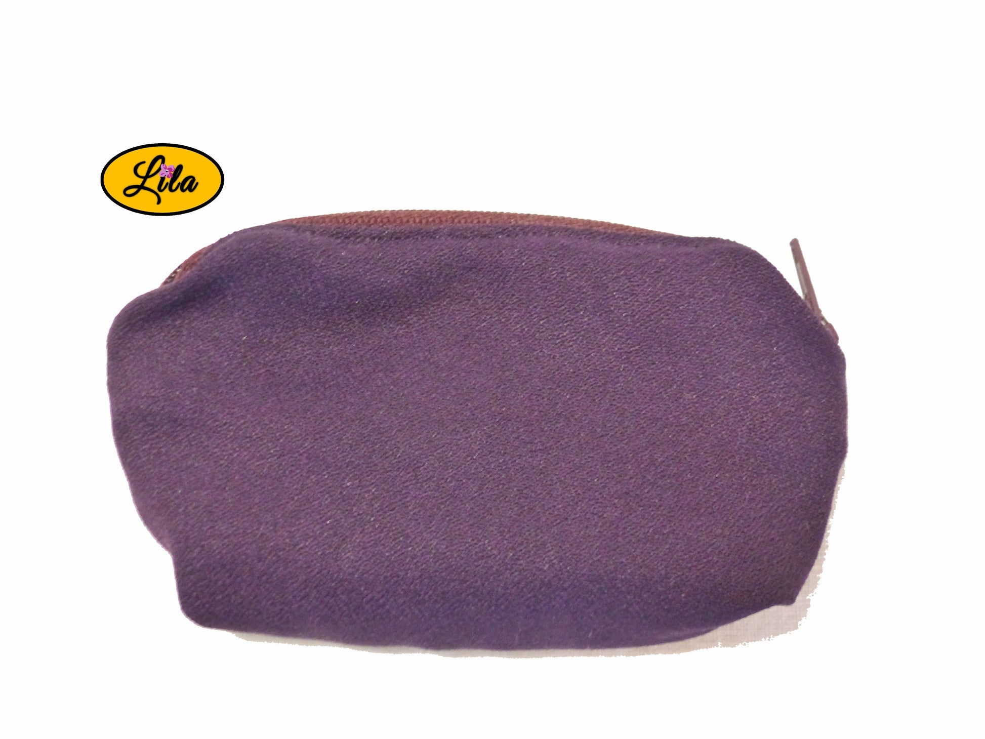 Porte-monnaie mauve avec fermeture éclair bordeaux posé de face vue de haut sur fond blanc style féminin et élégant