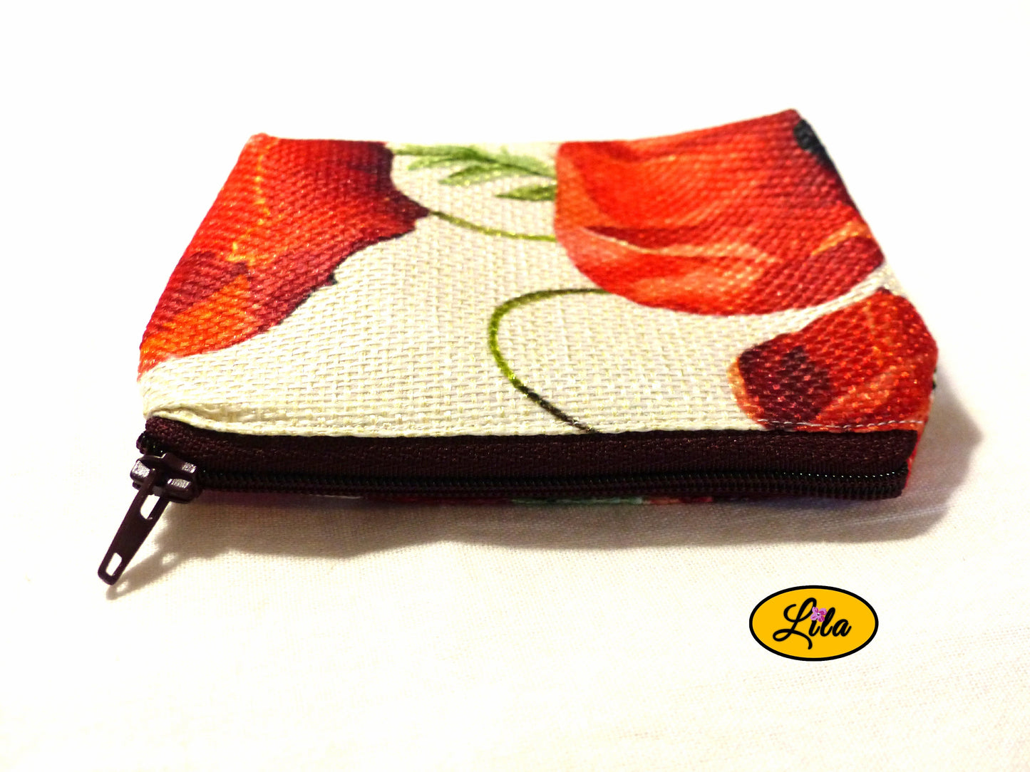 Porte-monnaie en tissu vintage à motifs coquelicots avec fermeture éclair bordeaux posé de face avec fermeture visible sur fond blanc style romantique et pratique