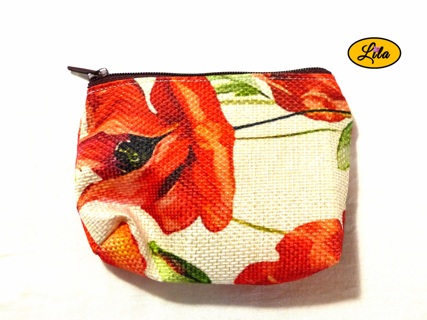 Porte-monnaie en tissu vintage à motifs coquelicots issu d’une ancienne nappe avec fermeture éclair bordeaux posé de face vue de haut sur fond blanc style rétro et artisanal