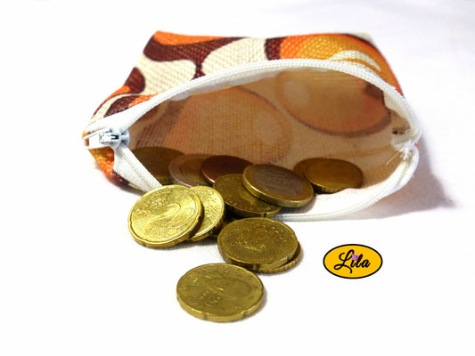 Porte-monnaie en tissu vintage à motifs ronds orange ouvert avec pièces de monnaie qui en sortent sur fond blanc style artisanal et fonctionnel