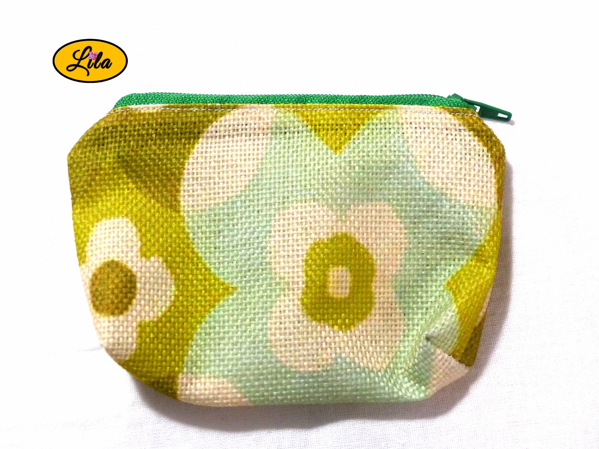 Porte-monnaie en tissu vintage vert fleuri issu d’une ancienne nappe avec fermeture éclair verte posé de face vue de haut sur fond blanc style bohème et artisanal