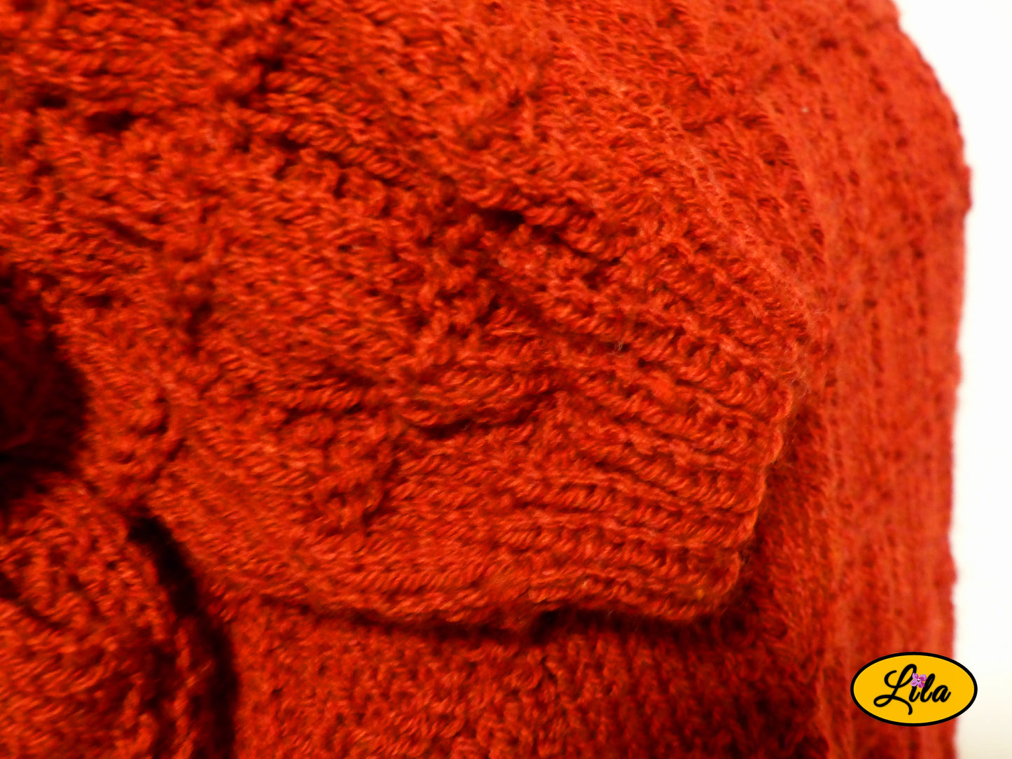 Zoom sur une manche du pull Elise bordeaux tricoté à la main taille XXL 48-50 posée sur le pull détail texture et finition artisanale