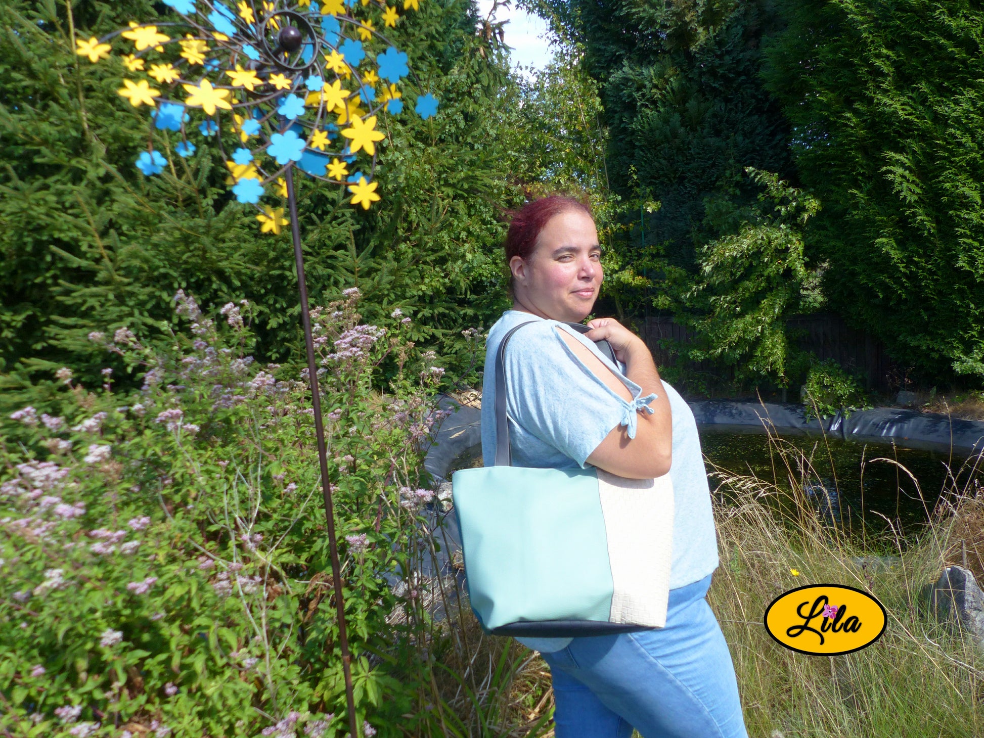 Sac 4 saisons en simili cuir crème et vert porté à l’épaule par une femme en jeans et haut vert devant un étang style chic quotidien
