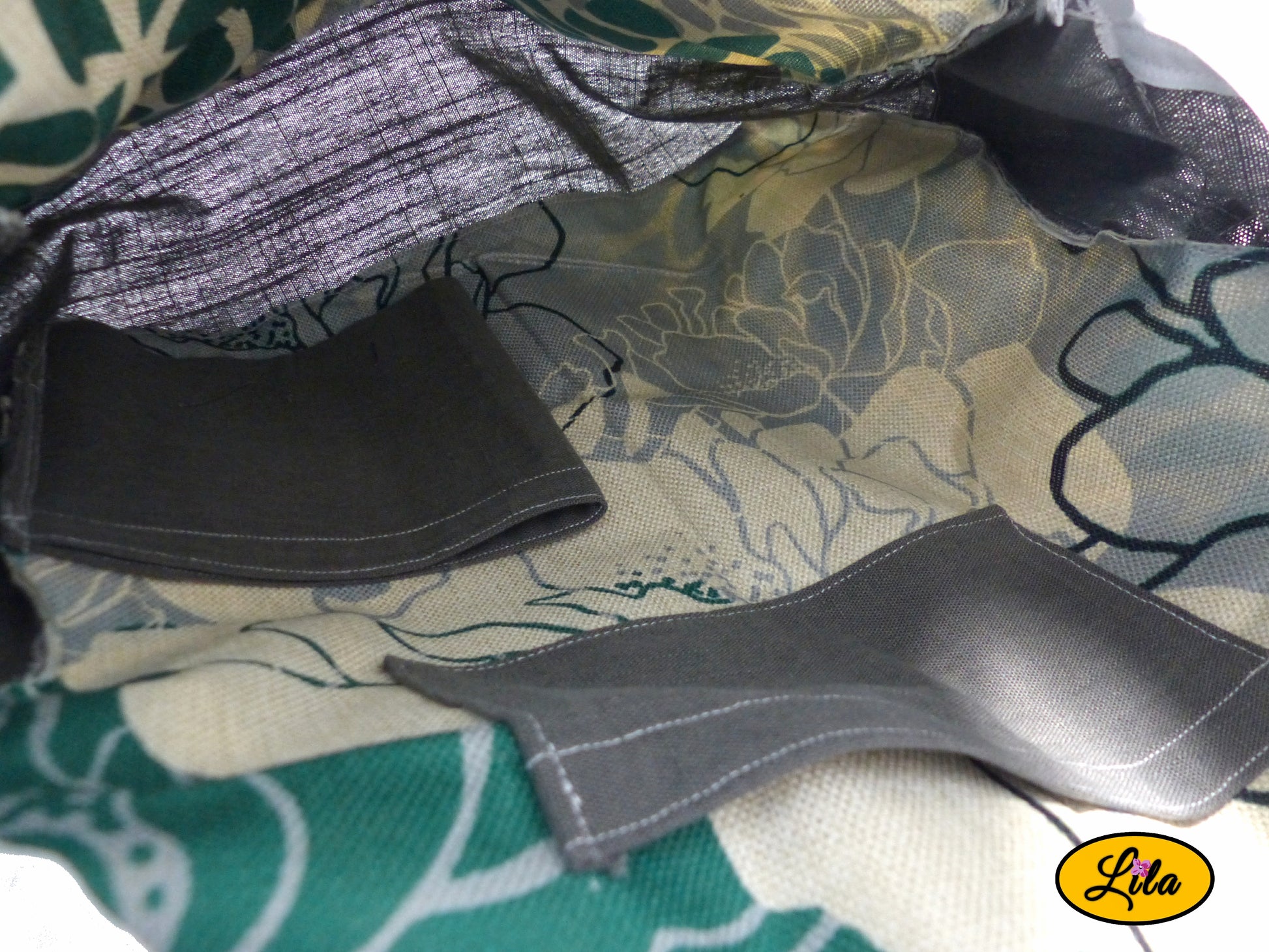 Intérieur d’un sac à dos artisanal avec doublure florale graphique, poche de rangement intégrée et porte-bouteille gris visible style pratique et organisé