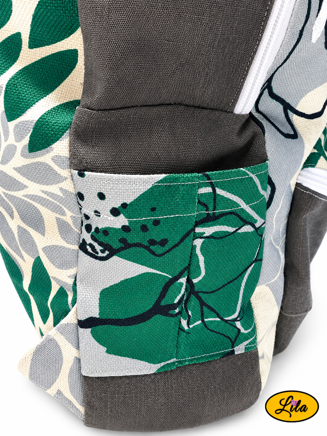 Zoom sur la poche porte-bouteille latérale droite d’un sac à dos artisanal gris et floral graphique