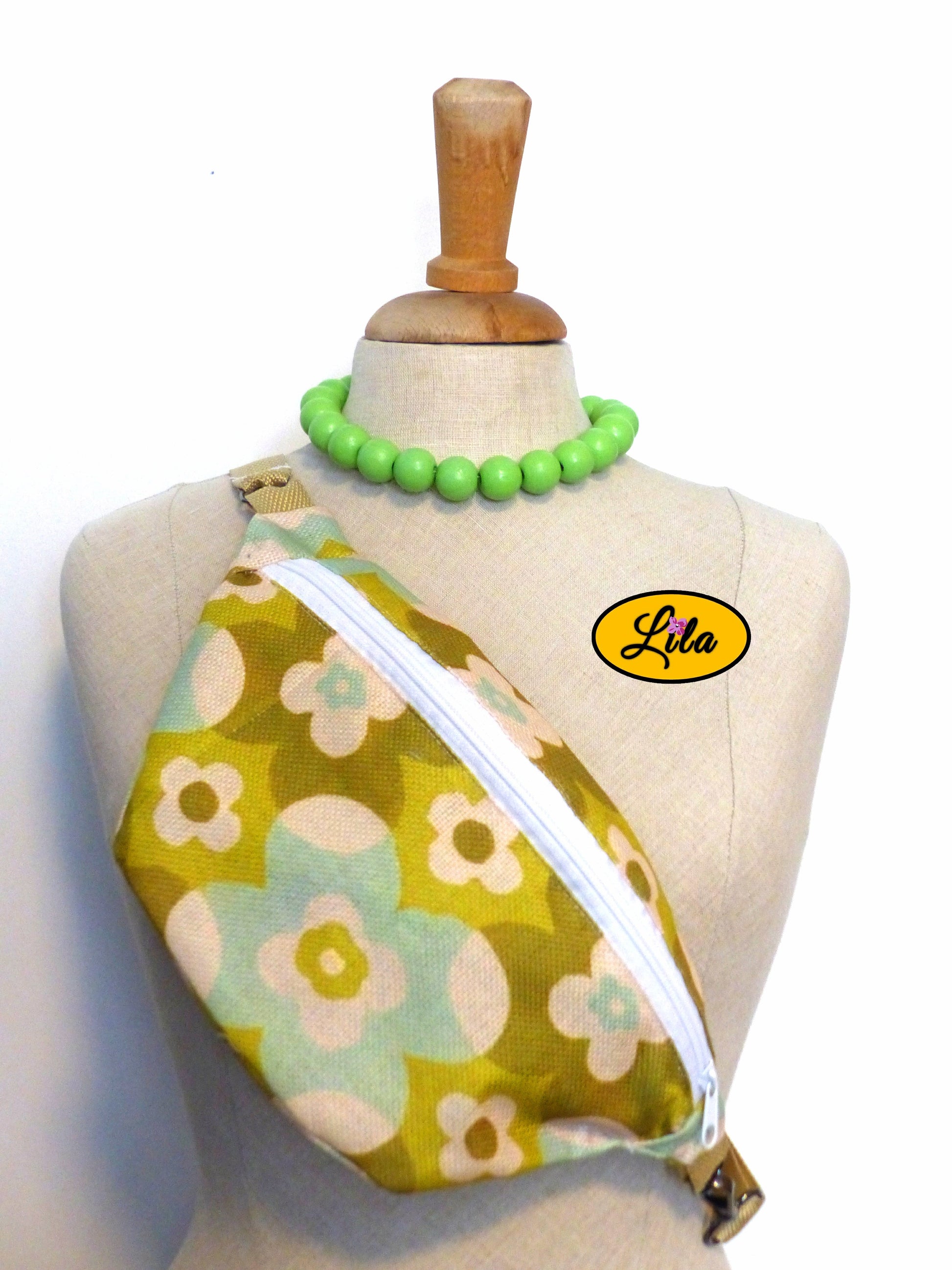 Sac banane en tissu au motif fleuri vert vintage présenté sur mannequin de couture sur fond blanc style bohème et rétro