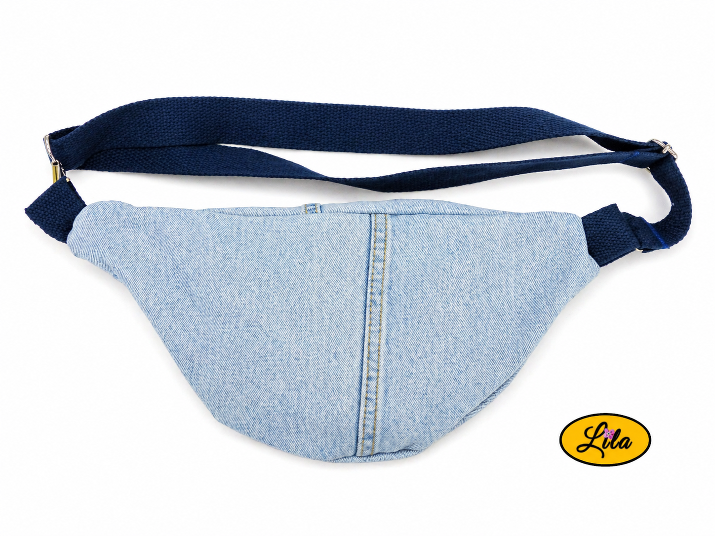 Sac banane en jeans clair avec sangle bleu foncé posé à plat vue de dos sur fond blanc style minimaliste et urbain