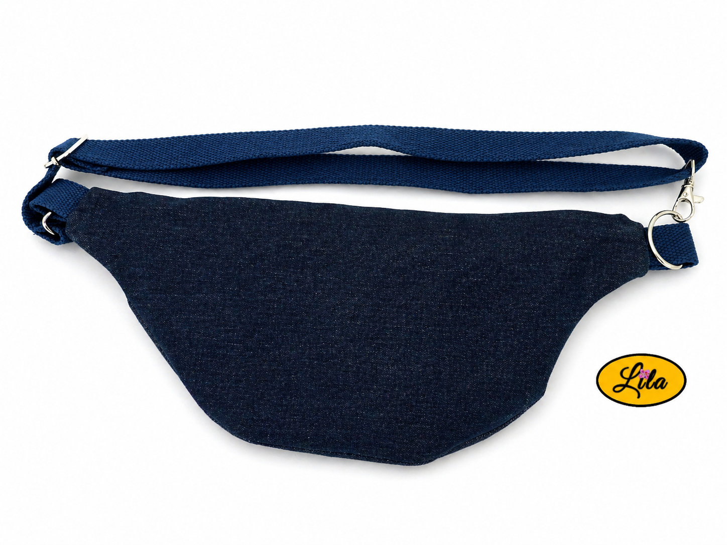 Sac banane en patchwork de jeans recyclés avec sangle bleue posé à plat vue de dos avec sangle au-dessus sur fond blanc style casual et artisanal
