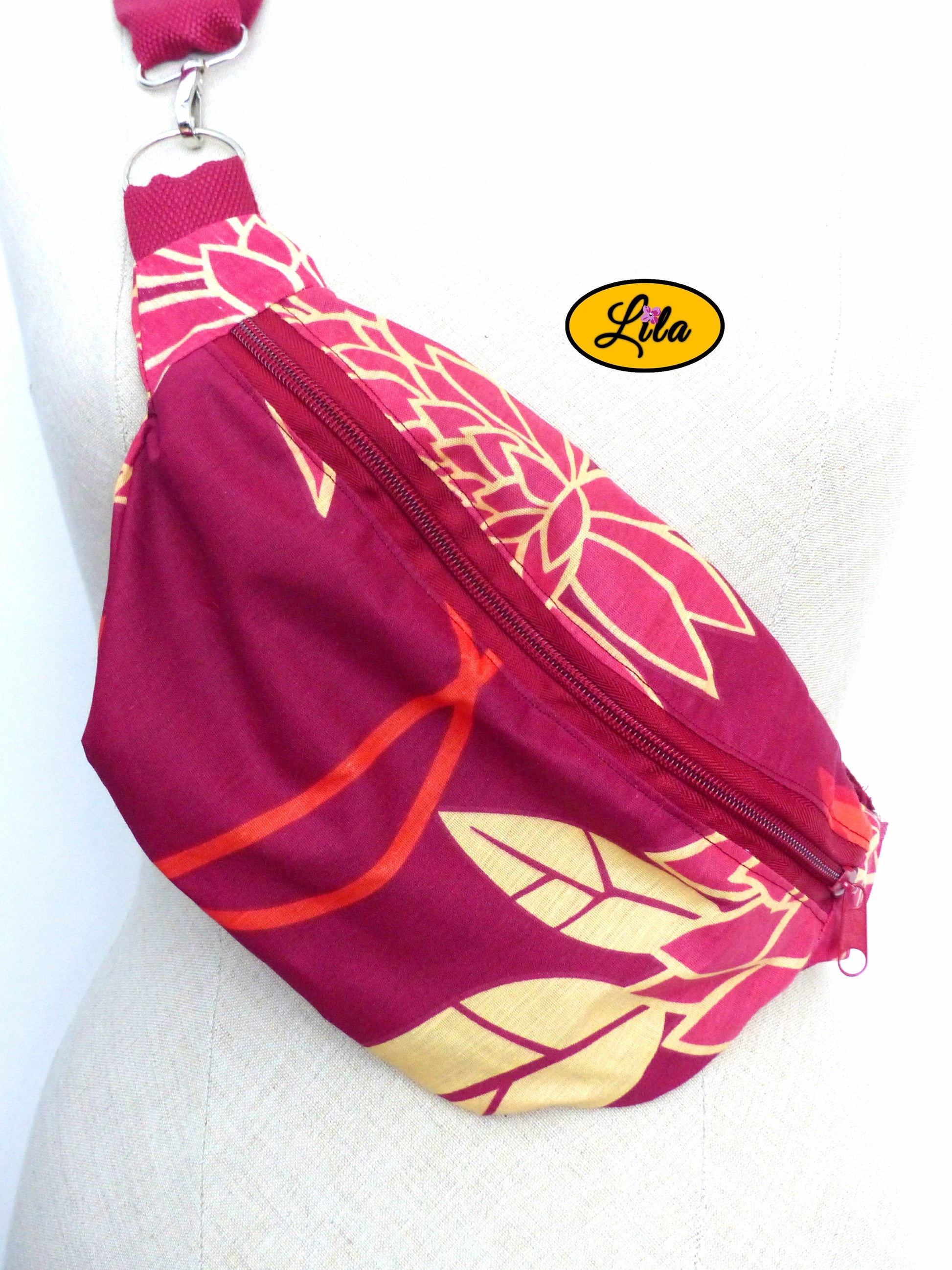 Zoom sur un sac banane rouge fleuri porté sur mannequin de couture mettant en valeur les détails du tissu et les motifs floraux style artisanal et rétro