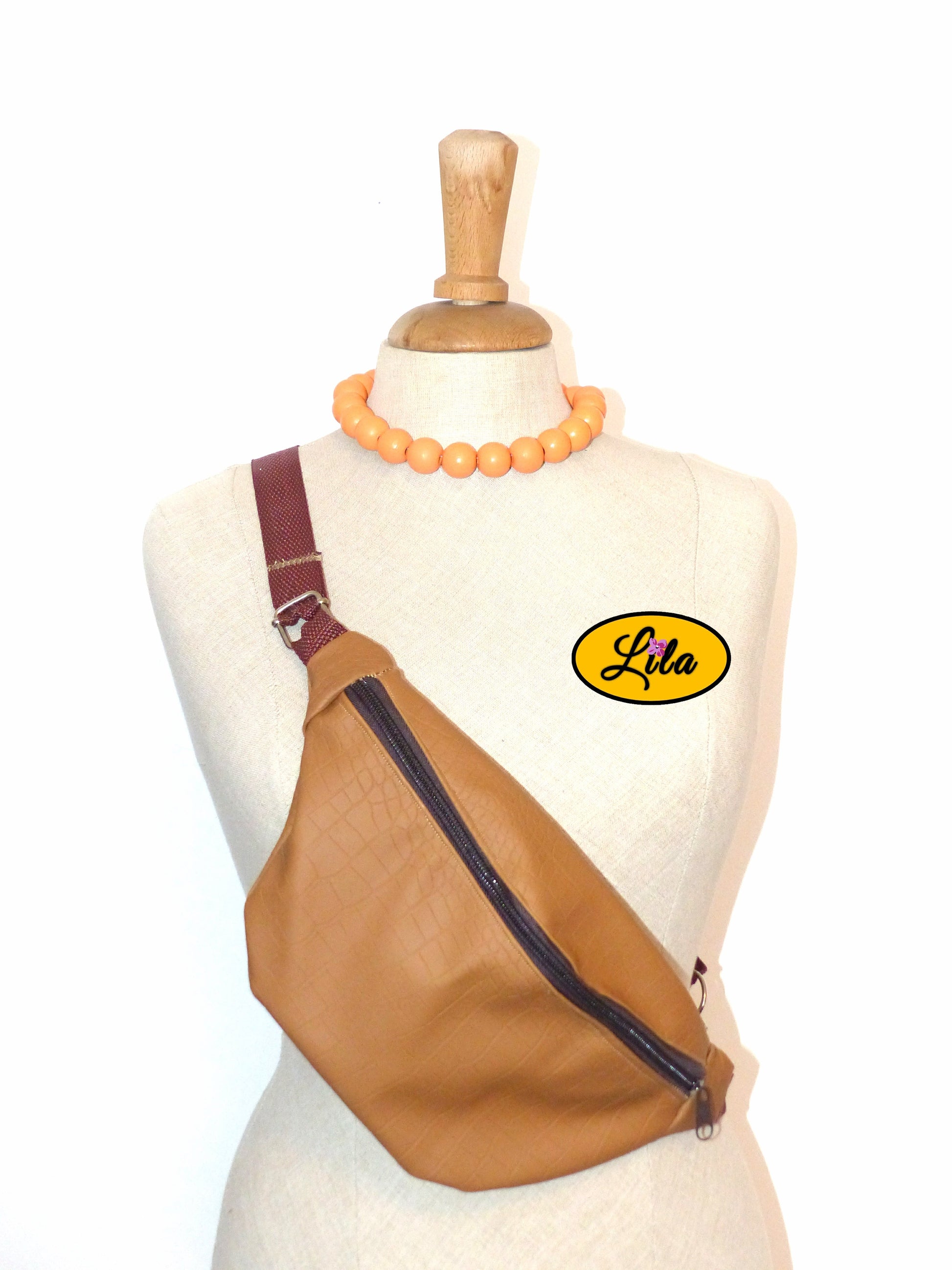 Sac banane en simili brun craquelé présenté sur mannequin de couture sur fond blanc style vintage et artisanal
