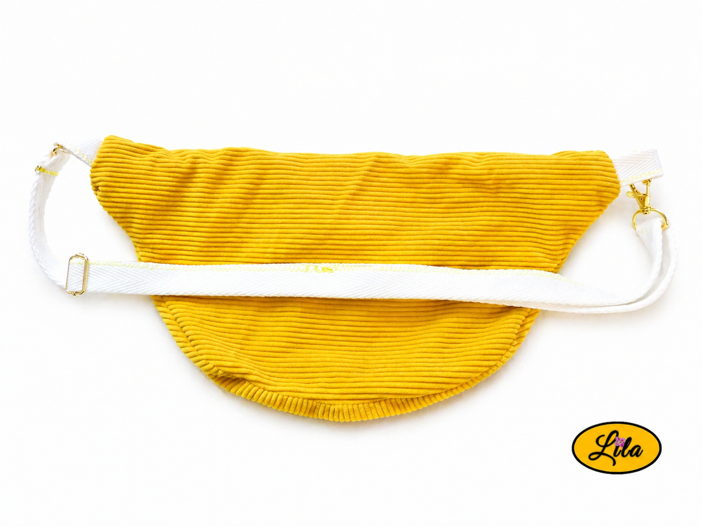 Sac banane en velours côtelé jaune avec sangle blanche posé à plat vue de dos sur fond blanc avec sangle visible sur le sac style urbain et tendance