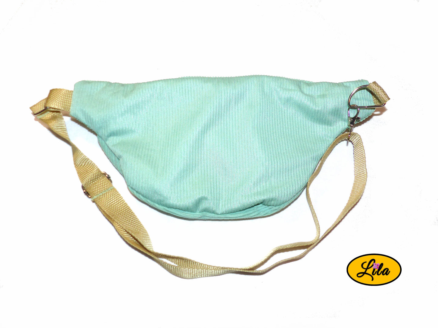 Sac banane en velours côtelé vert menthe avec sangle assortie et anse couleur sable posé à plat vue de dos sur fond blanc style artisanal et tendance