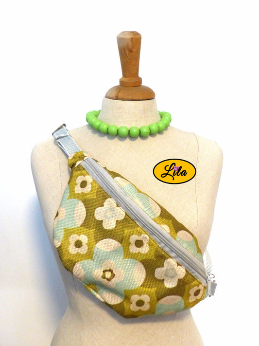 Sac banane en tissu vintage vert fleuri présenté sur mannequin de couture sur fond blanc style bohème et artisanal