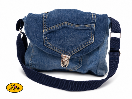 Sac bandoulière en patchwork de jeans recyclés vu de face sur fond blanc avec sangle positionnée sur le devant, rabat en poche de jean et fermeture cartable métallique