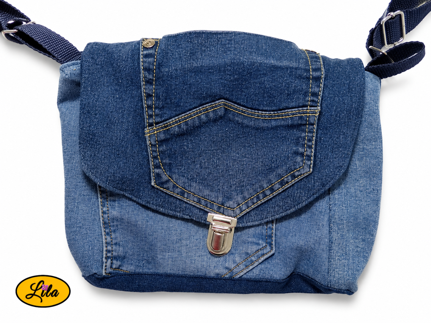Zoom sur un sac bandoulière en patchwork de jeans recyclés fermé sur fond blanc mettant en valeur le rabat réalisé avec une poche en jean, la fermeture cartable et les finitions artisanales