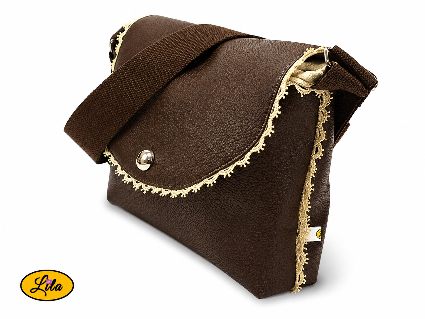 Sac bandoulière en simili cuir brun fermé légèrement de profil gauche sur fond blanc mettant en valeur la sangle en coton brun, les finitions et les détails en dentelle crème