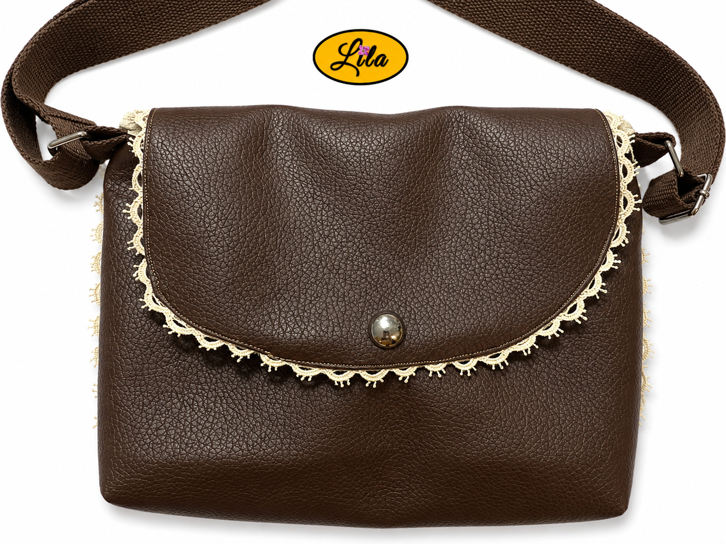 Zoom sur un sac bandoulière en simili cuir brun fermé vu de haut sur fond blanc mettant en valeur la fermeture à pression argentée, le rivet décoratif et les finitions artisanales