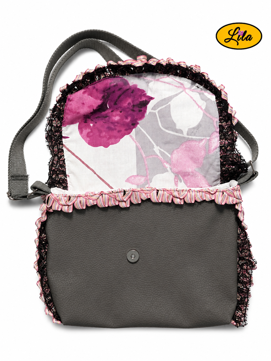 Sac bandoulière en simili cuir gris vu de haut avec rabat ouvert laissant apparaître une doublure blanche à motifs floraux roses et gris, une bordure plissée aux nuances de rose et un galon noir sur fond blanc