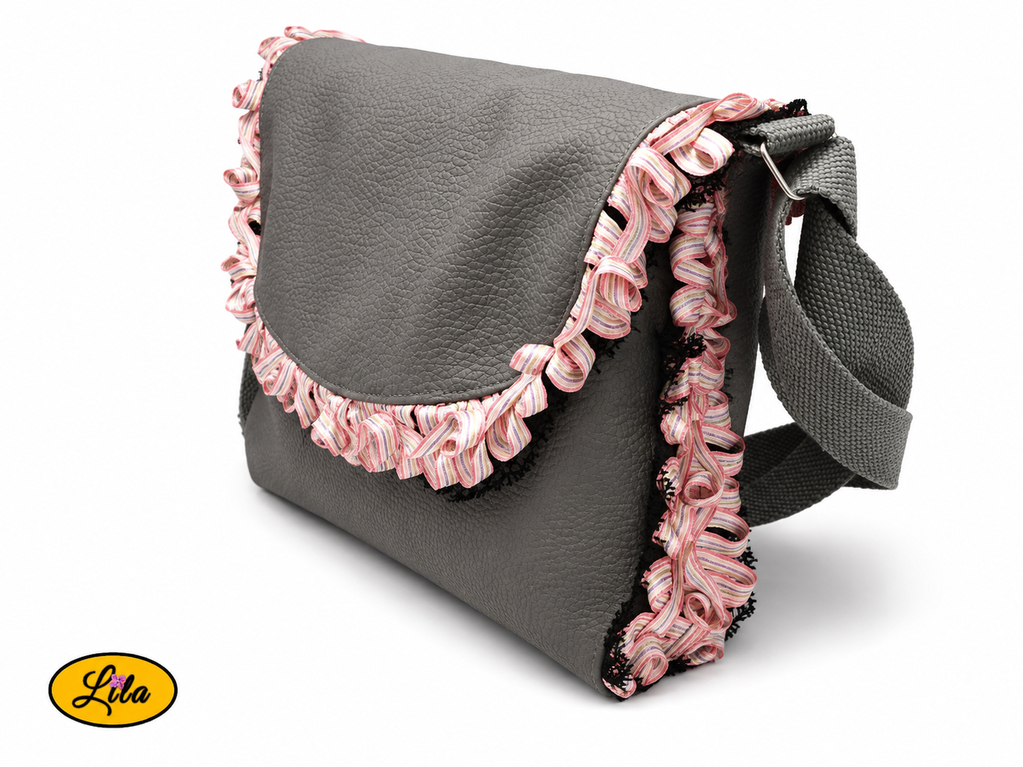 Sac bandoulière en simili cuir gris vu de profil gauche sur fond blanc mettant en valeur son épaisseur, sa bordure plissée aux nuances de rose, son galon noir et sa sangle en coton gris